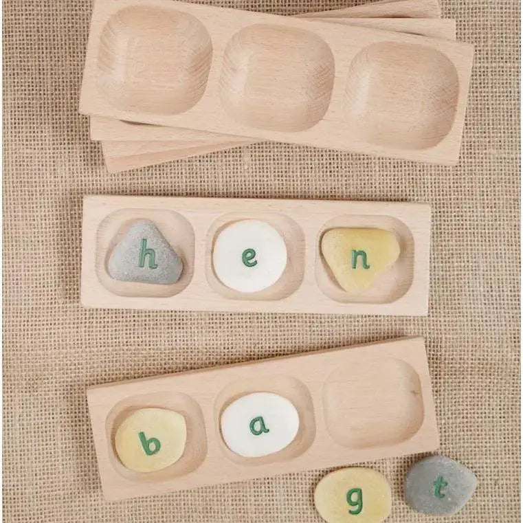 alphabet pebbles spelling hen in a wooden tray