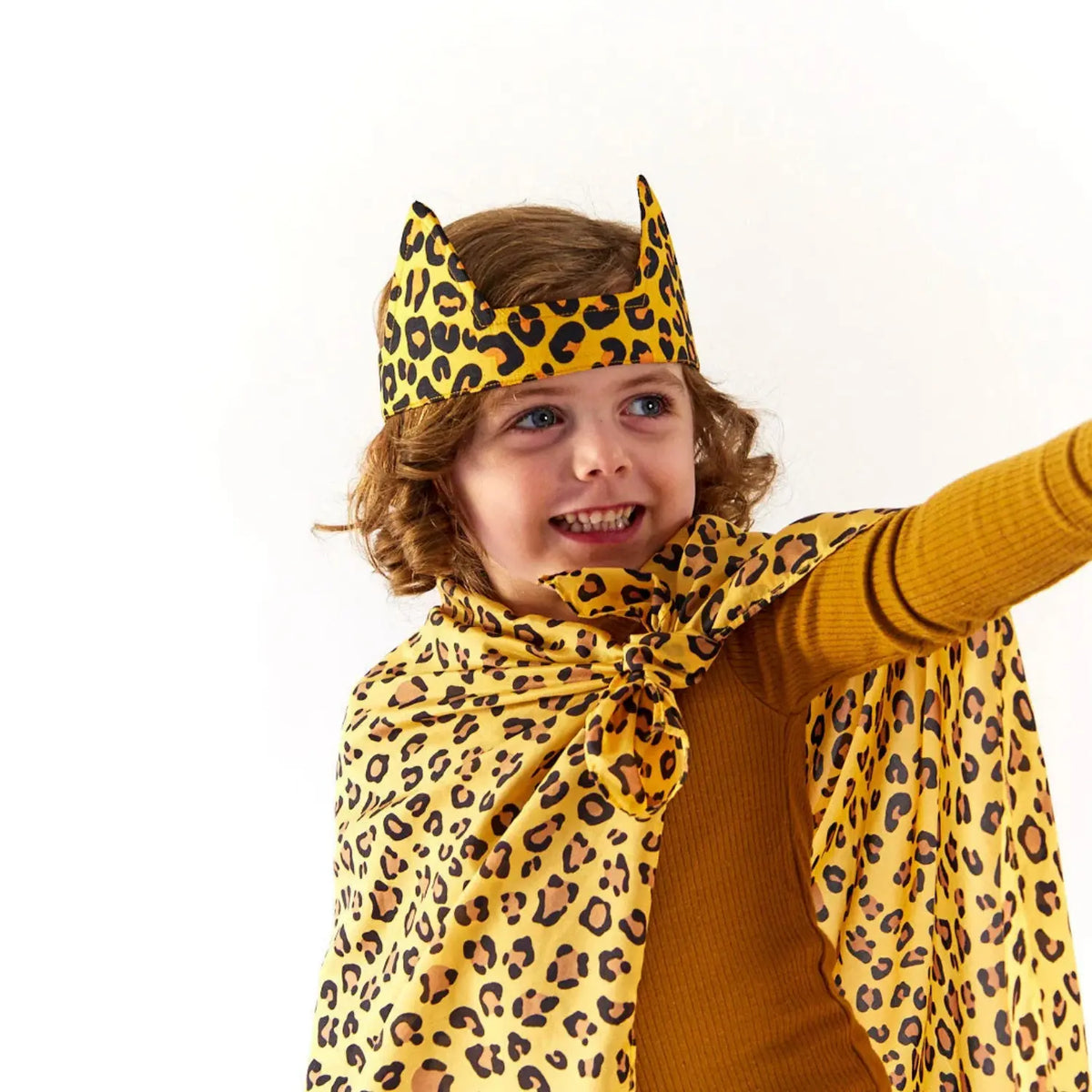 Smiling child wearing cheetah ears with a cheetah print playsilk tied as a cape for pretend play