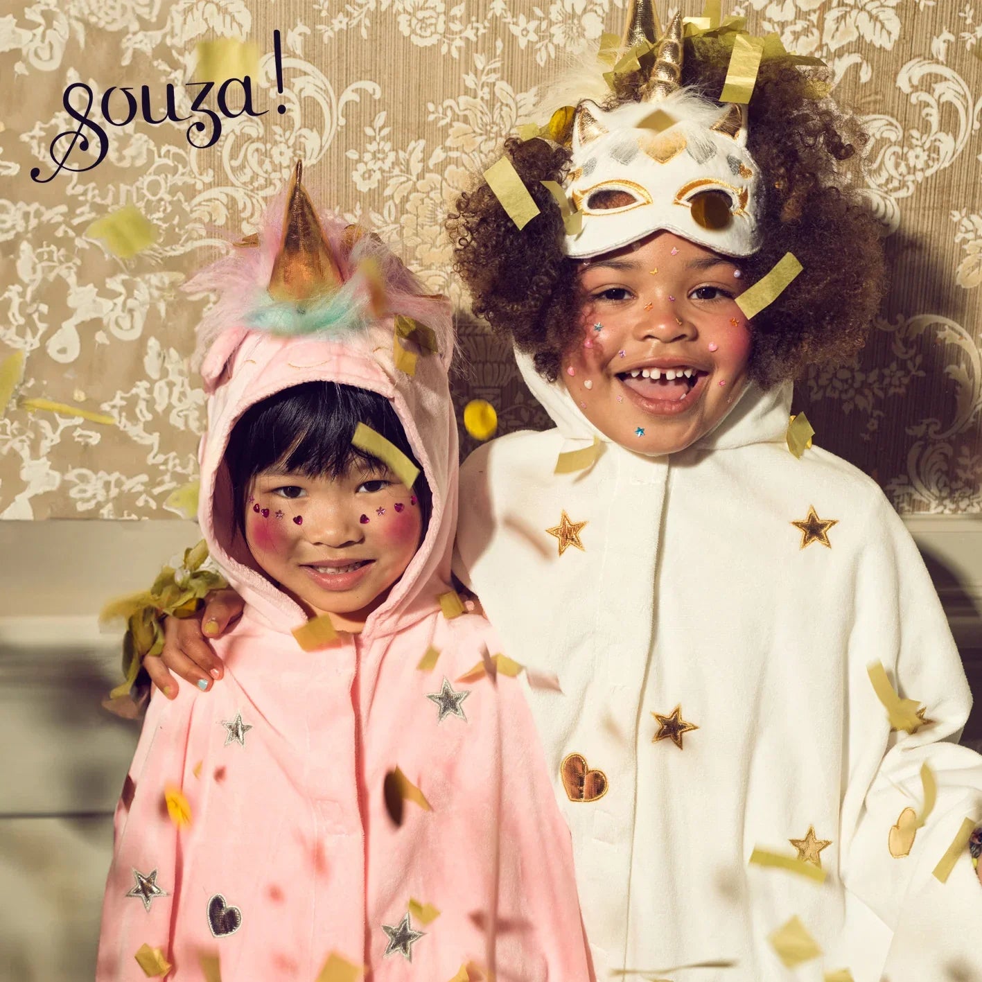 Children wearing pink and off-white unicorn capes for imaginative dress-up play