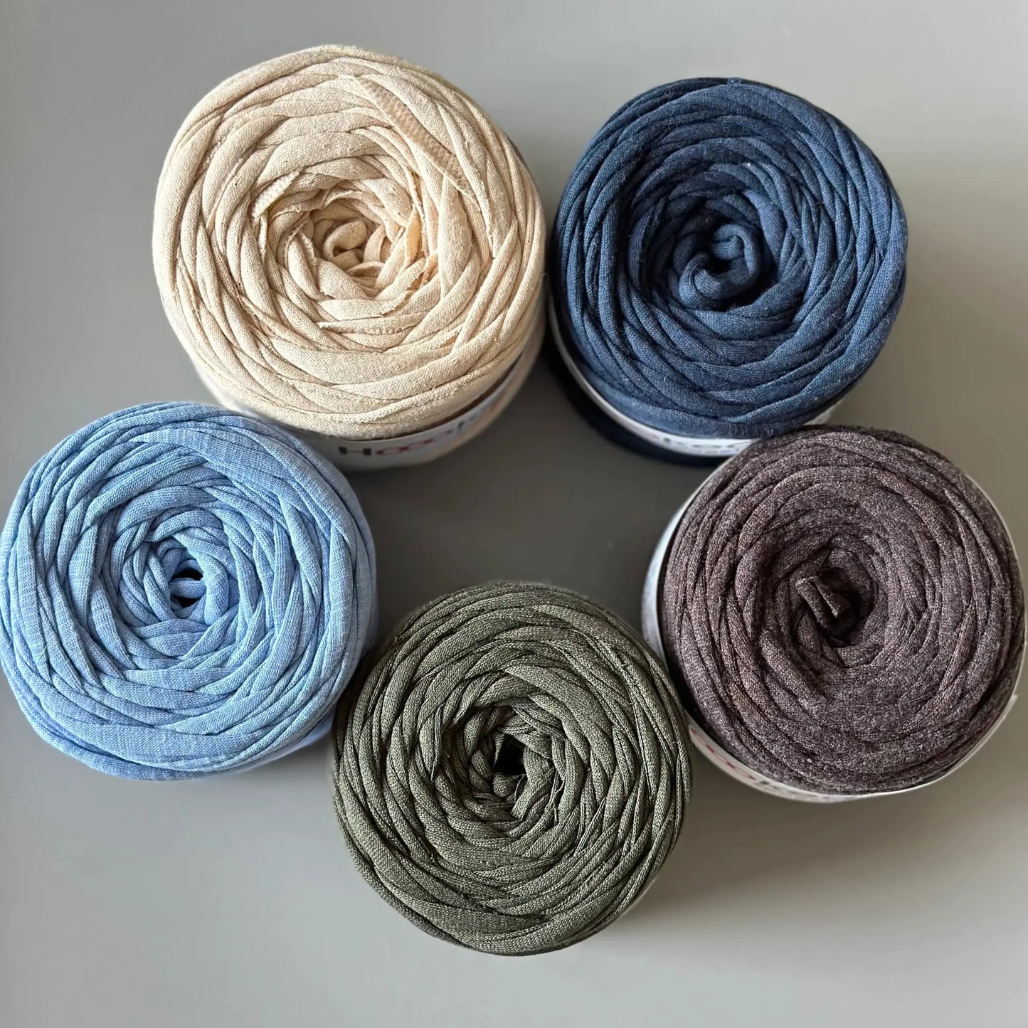 Recycled cotton tricot yarn balls in blue, gray, and neutral colors for wooden potholder loom projects