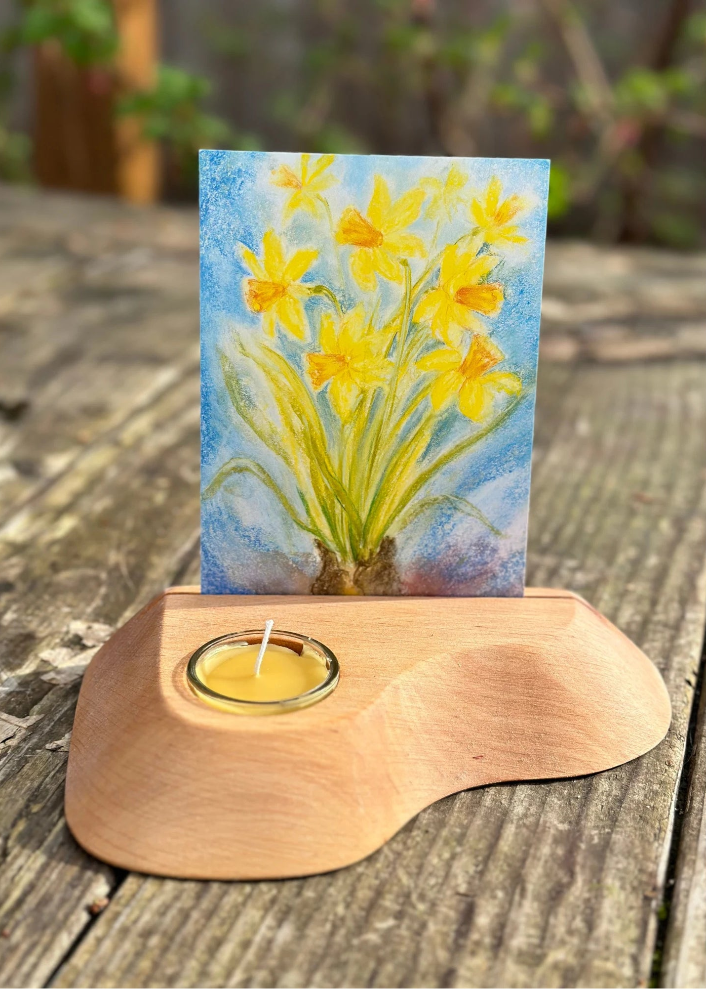 Yellow Daffodils postcard by Marjan van Zeyl in a wooden postcard holder with candle