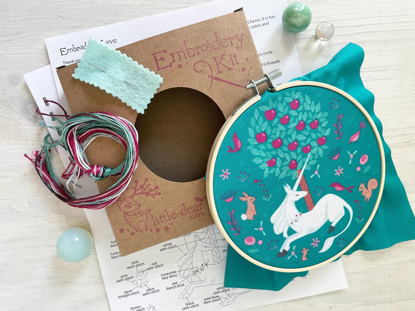 Embroidery kit with hoop, thread, and pattern sheet on a wooden surface