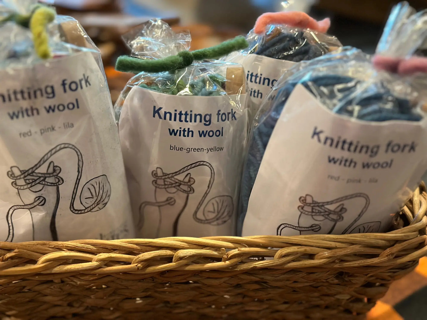 A close up view of several Knitting fork with wool lucet kits in a rattan basket