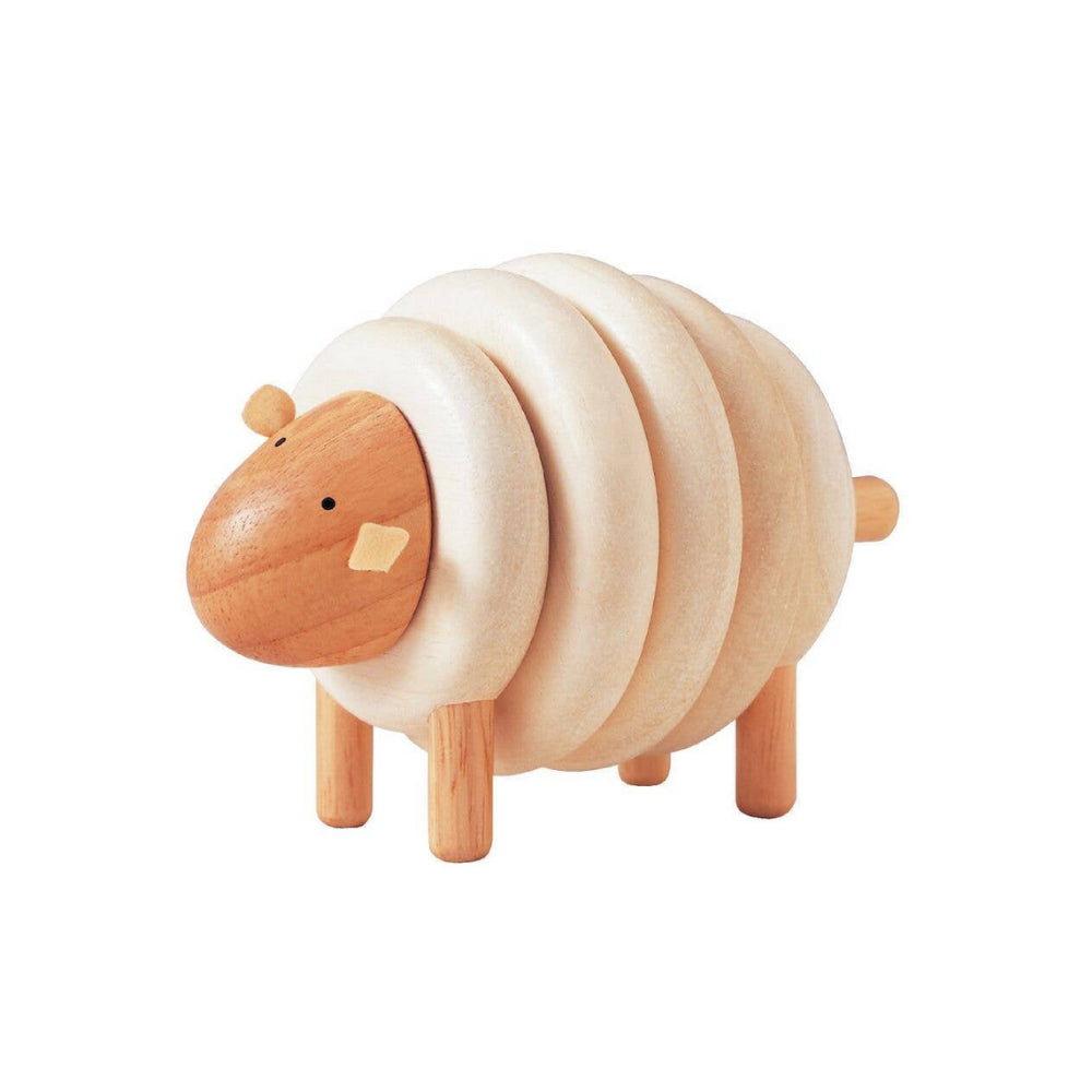 Wooden toy sheep with a white fleece on a white background