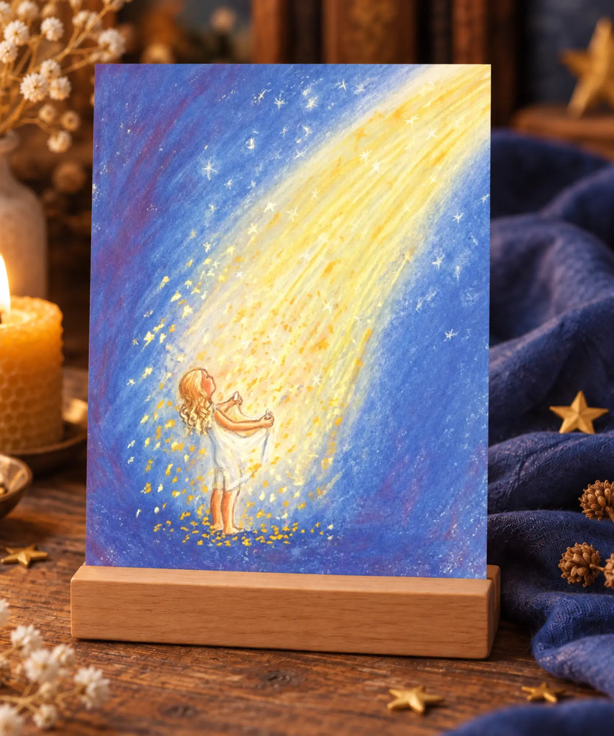 Marjan van Zeyl Star Money fairy tale postcard displayed in a wooden holder with a beeswax candle, golden stars, and blue linen on a Waldorf-inspired story table.
