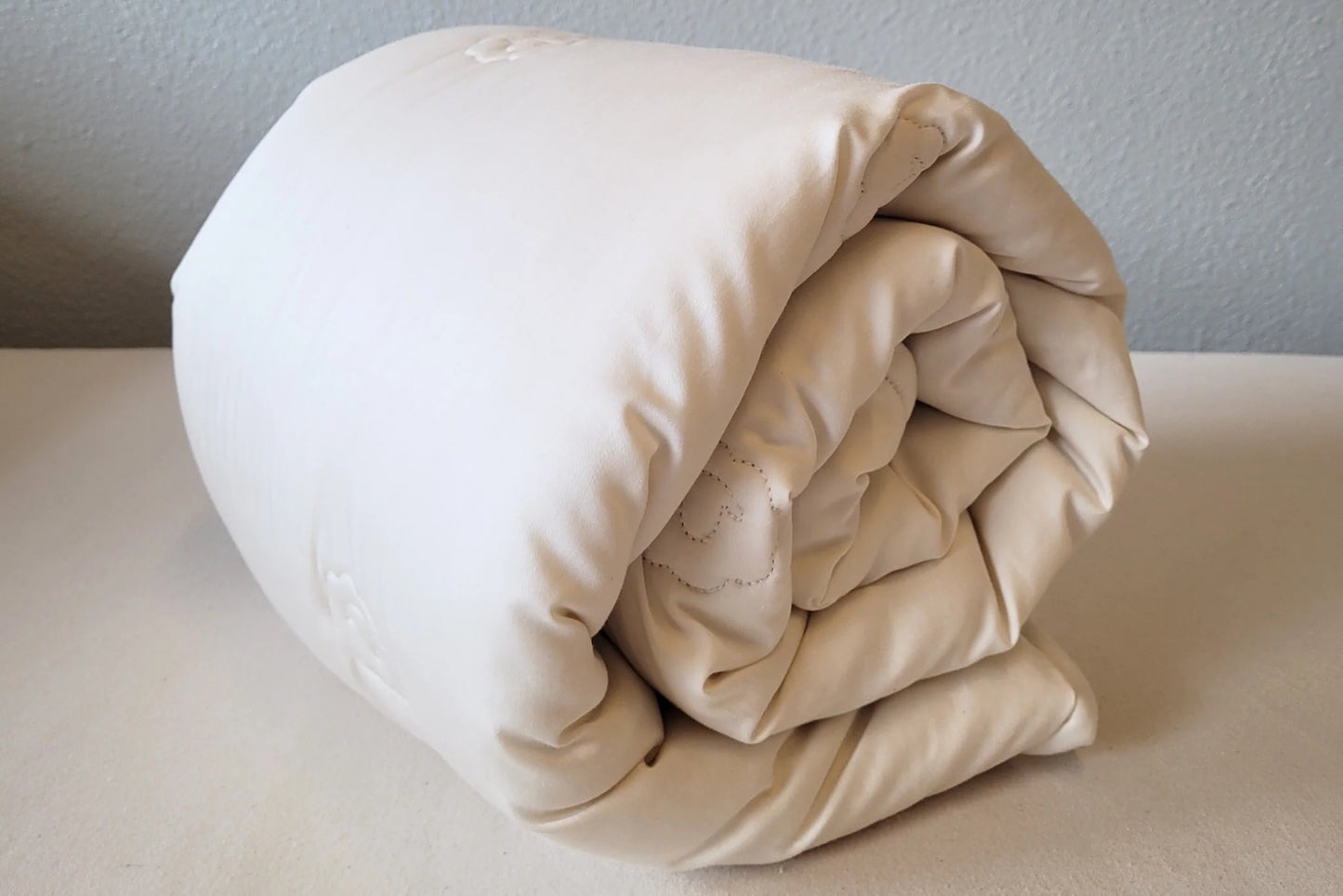 Eco-wool toddler comforter rolled up on a table
