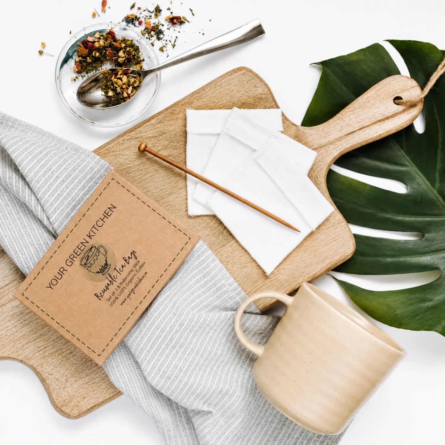 Set of three reusable organic cotton tea bags with wooden balancing stick, loose tea, and ceramic mug