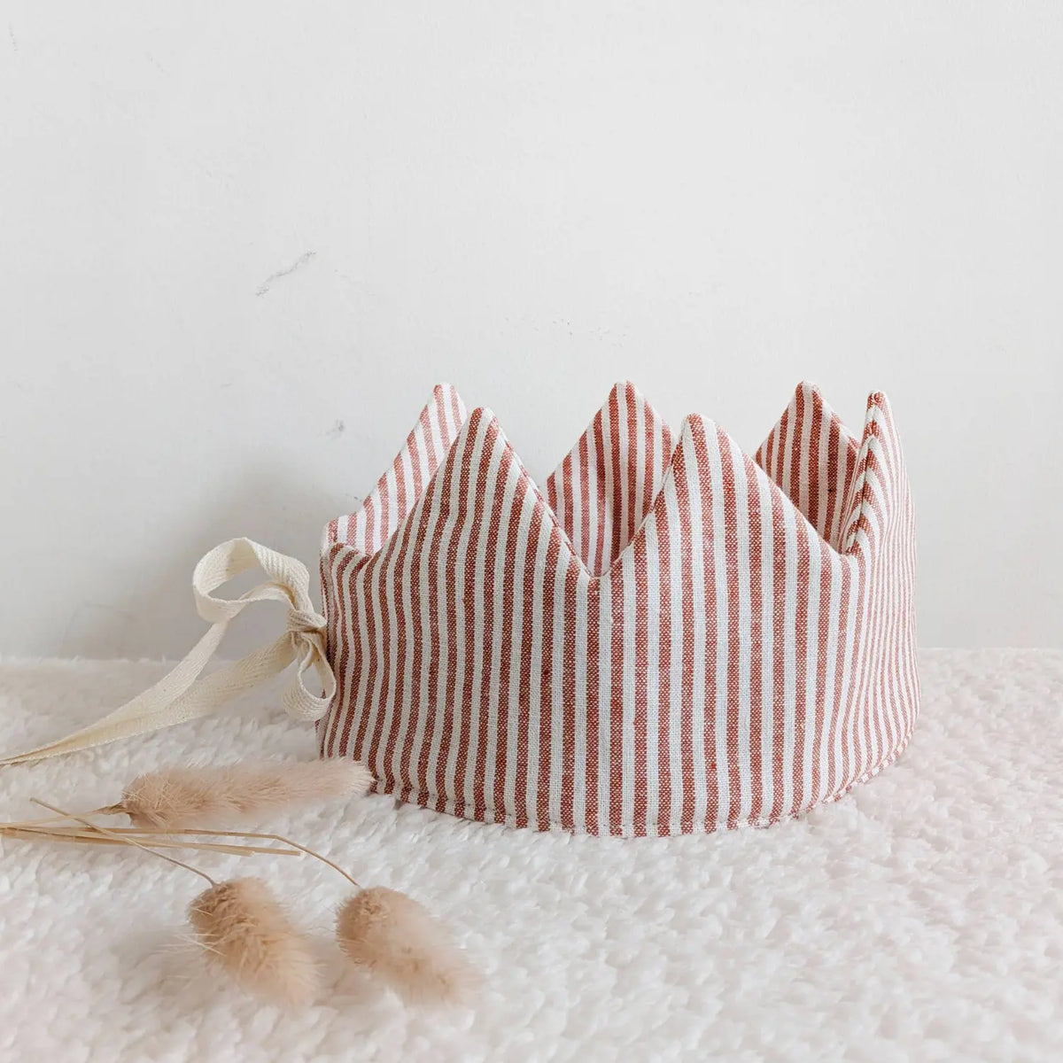 Red striped linen dress-up crown styled on a soft neutral background