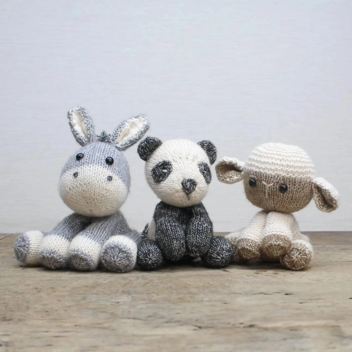 Finished knitted animals from Scheepjes yarn kits including panda, bunny, and lamb