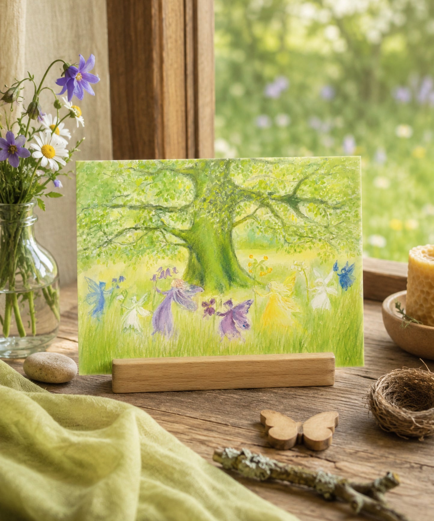 Fairy-themed greeting card on a wooden stand with flowers and nature elements.