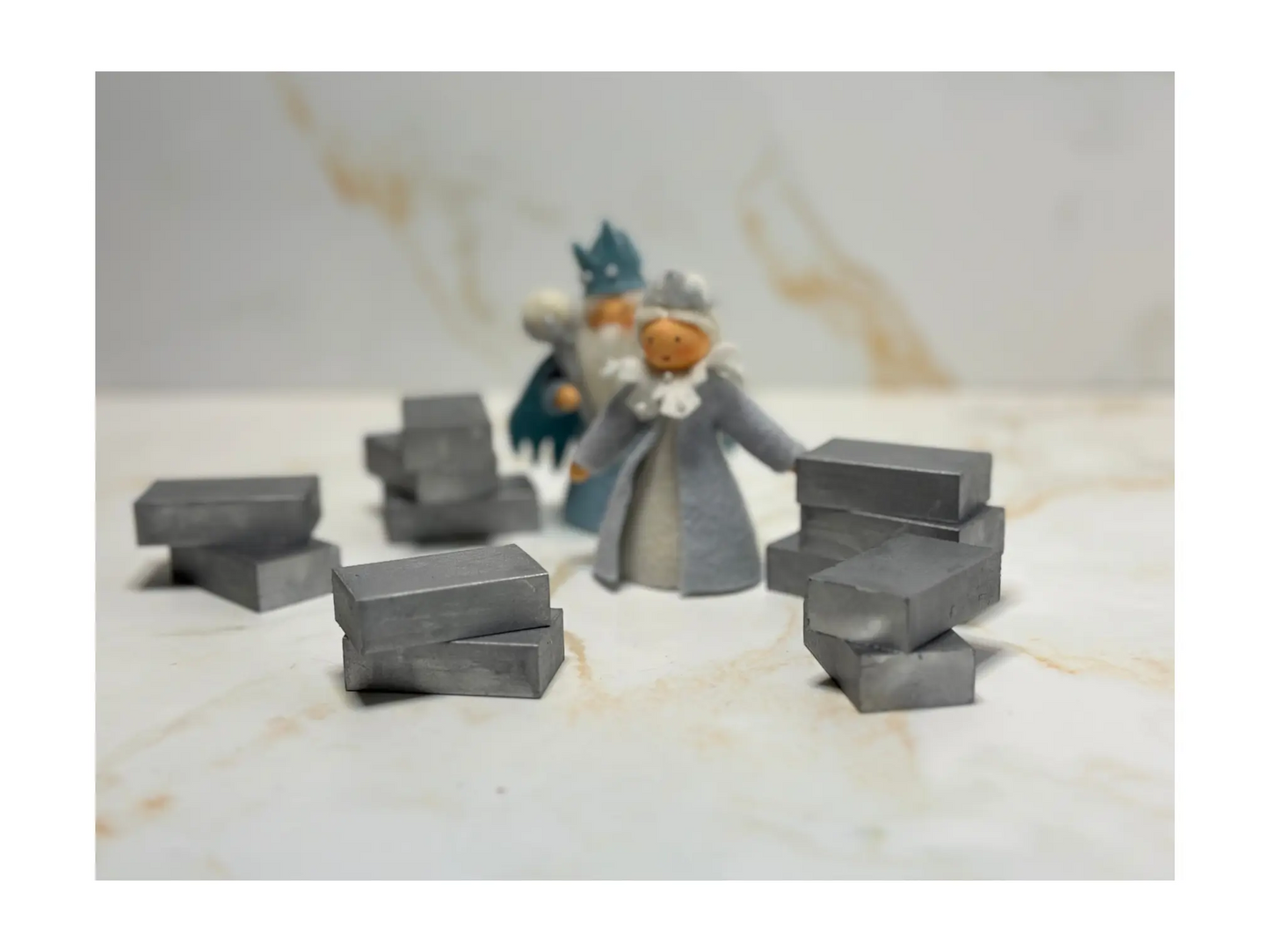 Small Stockmar silver block crayons and figurines on a marble surface
