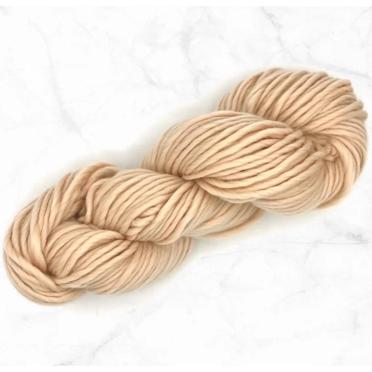 Beige skein of yarn on a white background