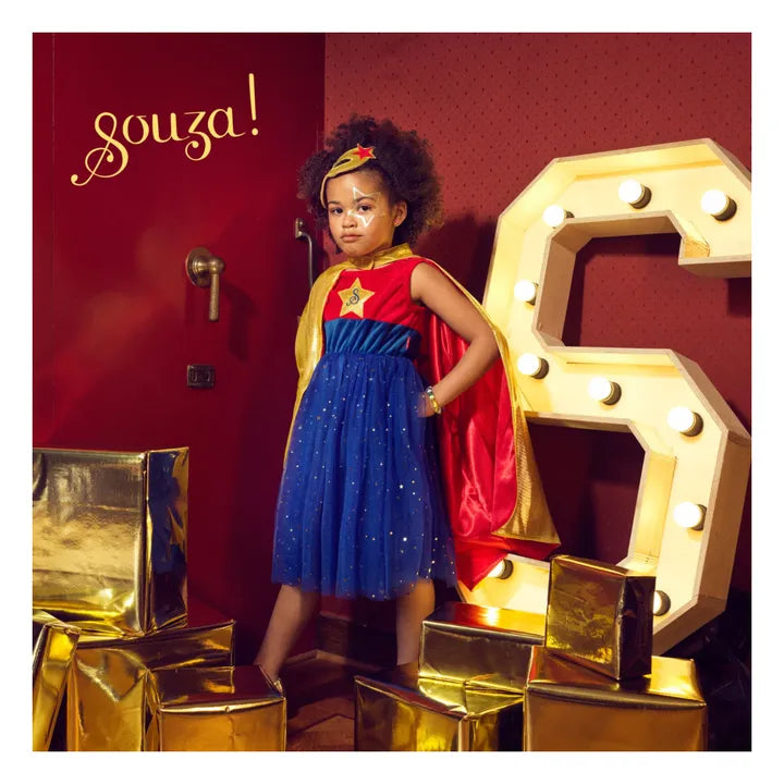 Child wearing superhero dress with tulle skirt and cape for dress-up and storytelling