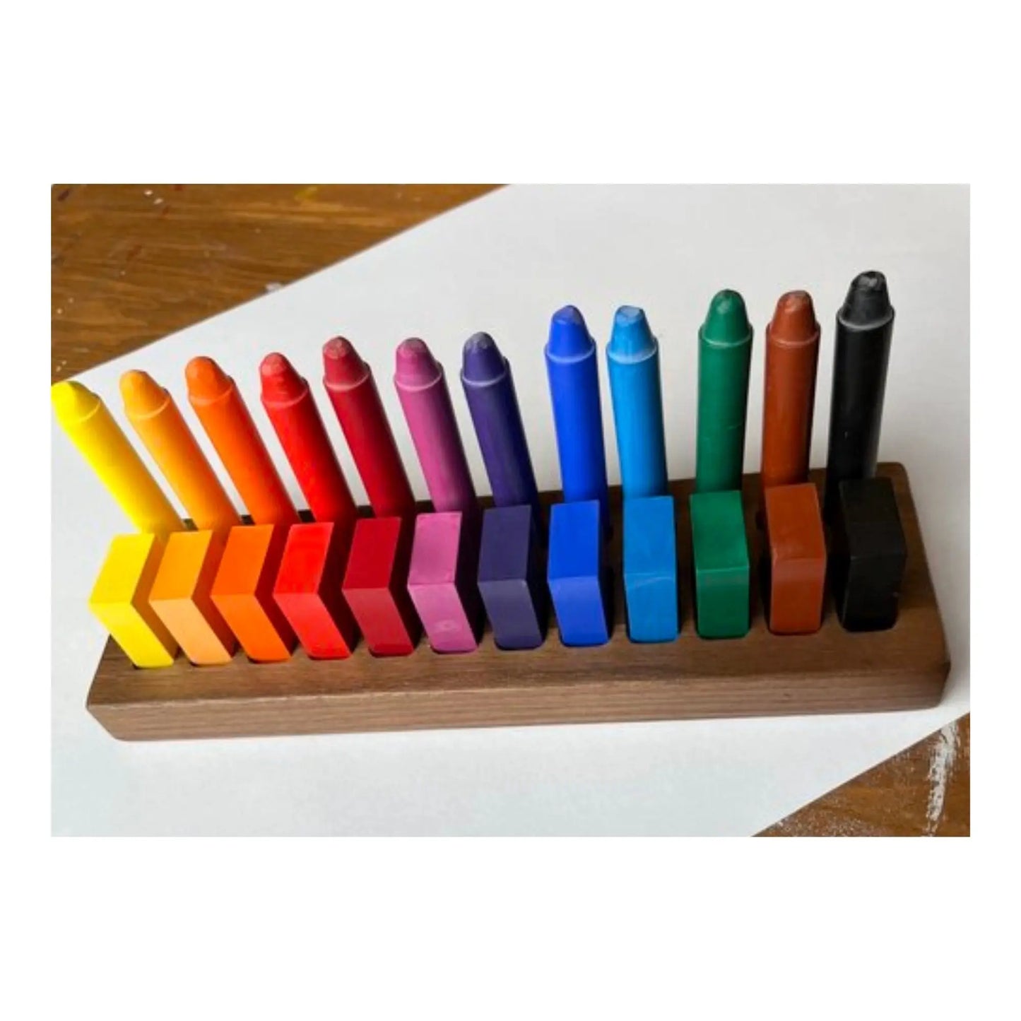 Set of colorful crayons in a wooden holder on a white background
