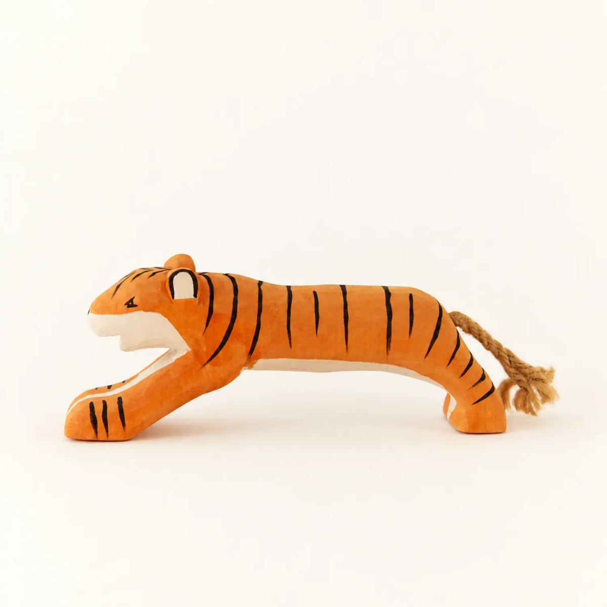 Wooden tiger toy shown on a warm ivory background