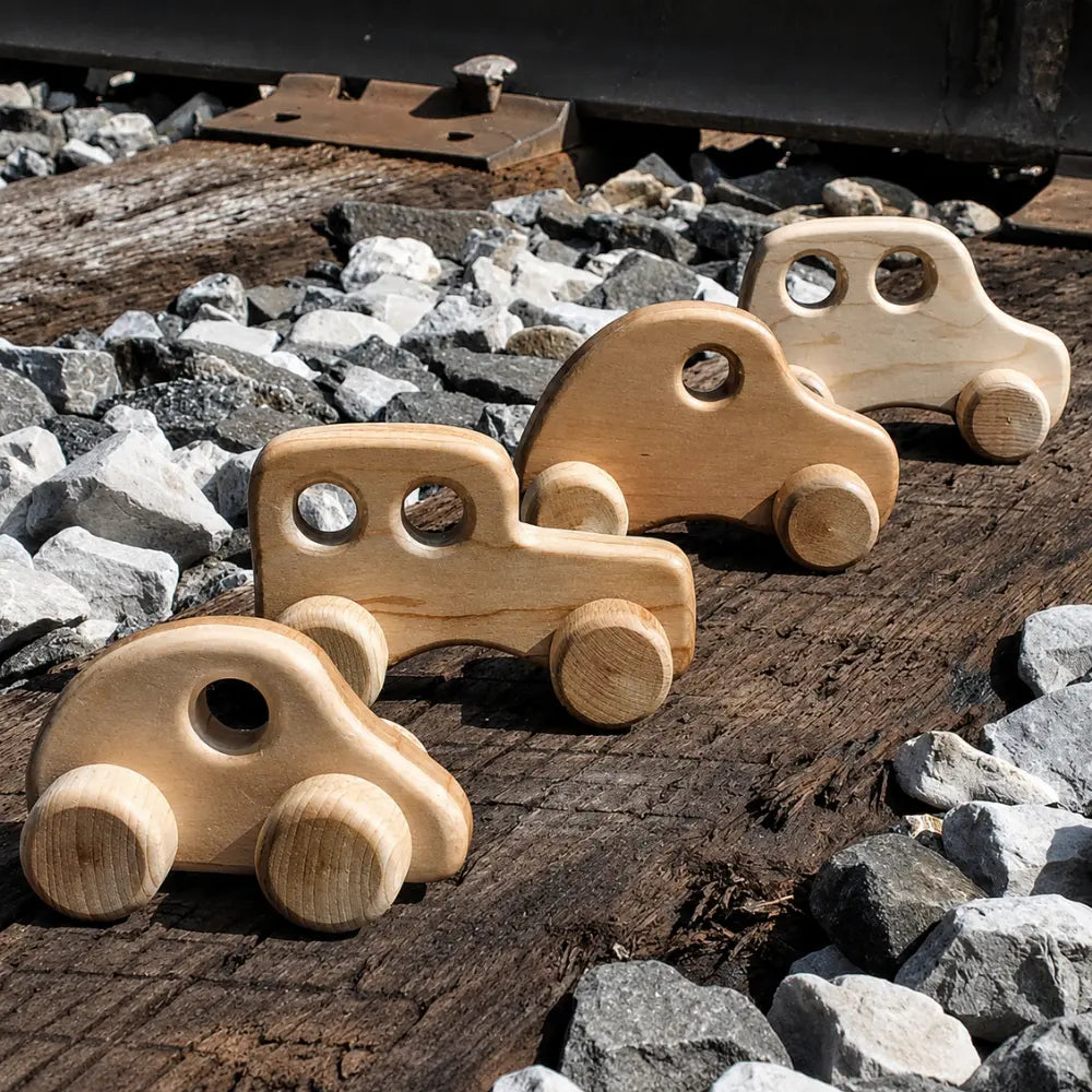 Wooden toy cars arranged on a small-world play road with stones