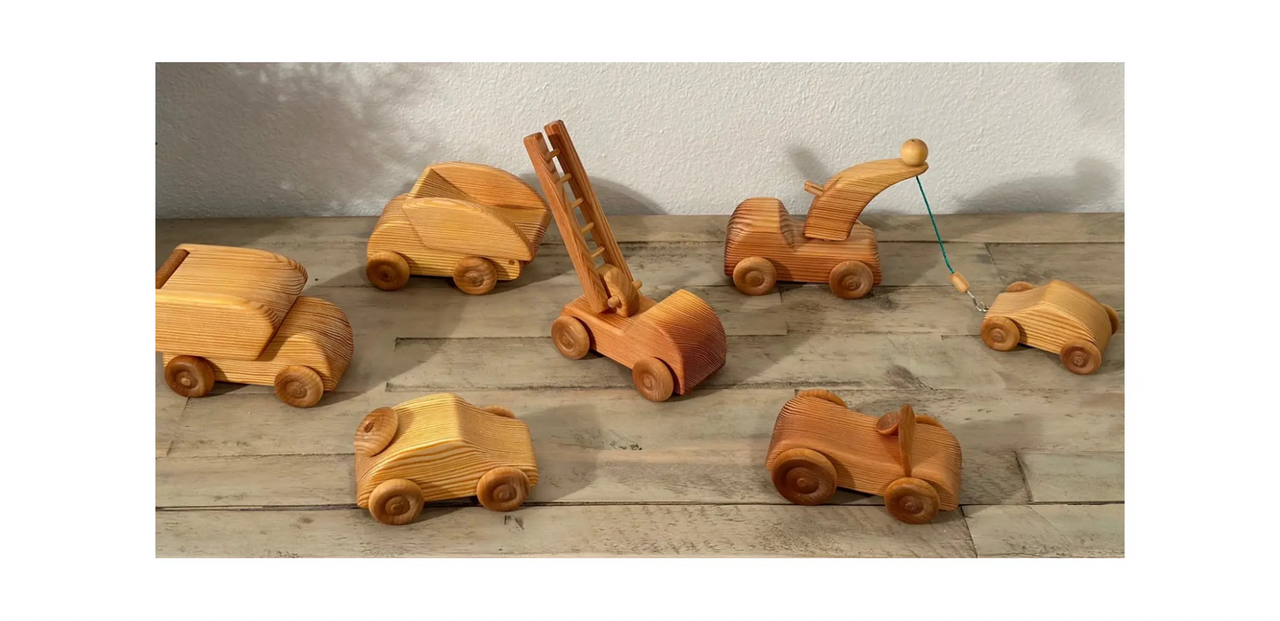 Set of wooden toy vehicles on a wooden surface with a neutral background