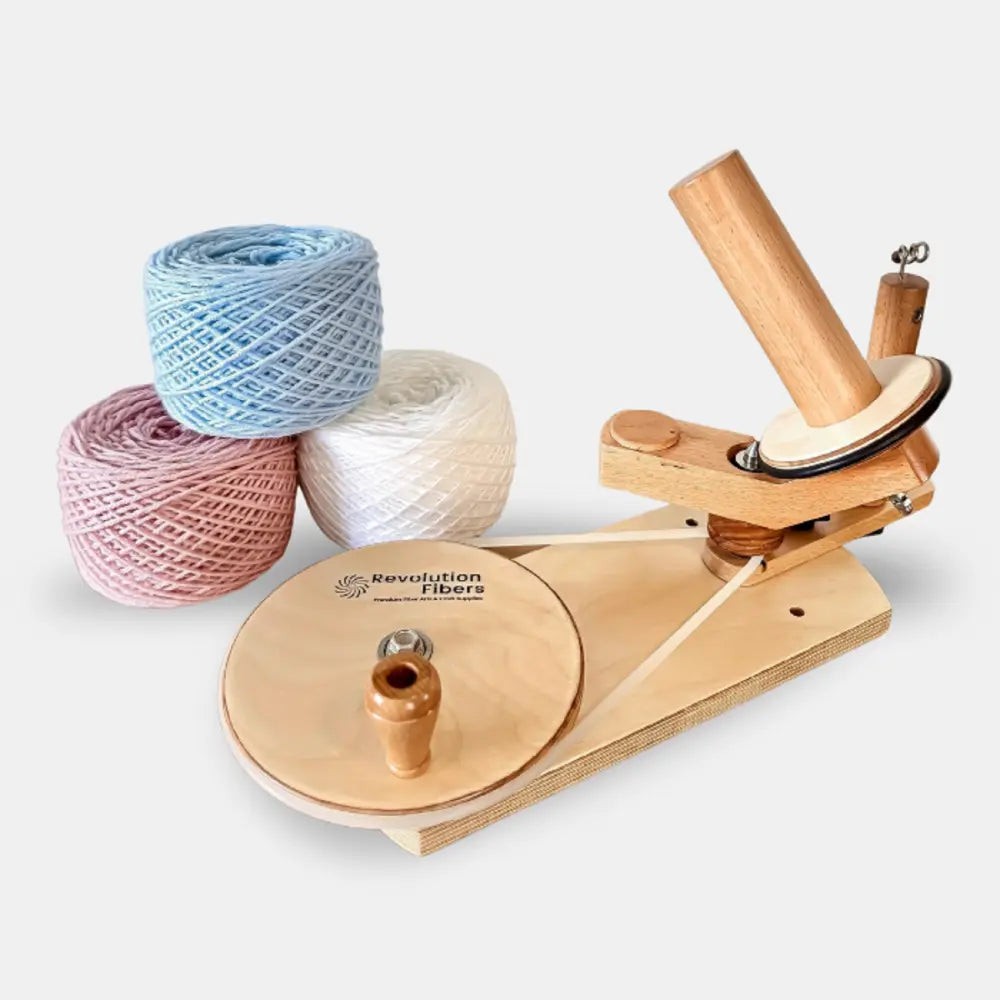 Wooden yarn winder with three balls of yarn on a white background