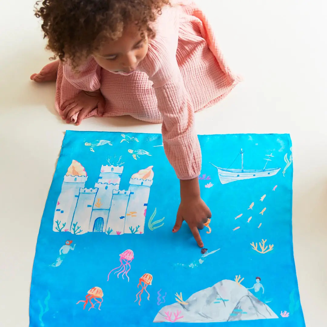 A child playing with the Under the Sea Playsilk