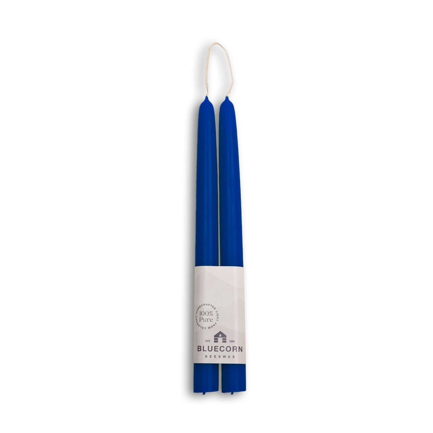 Two blue candles with a white label on a white background