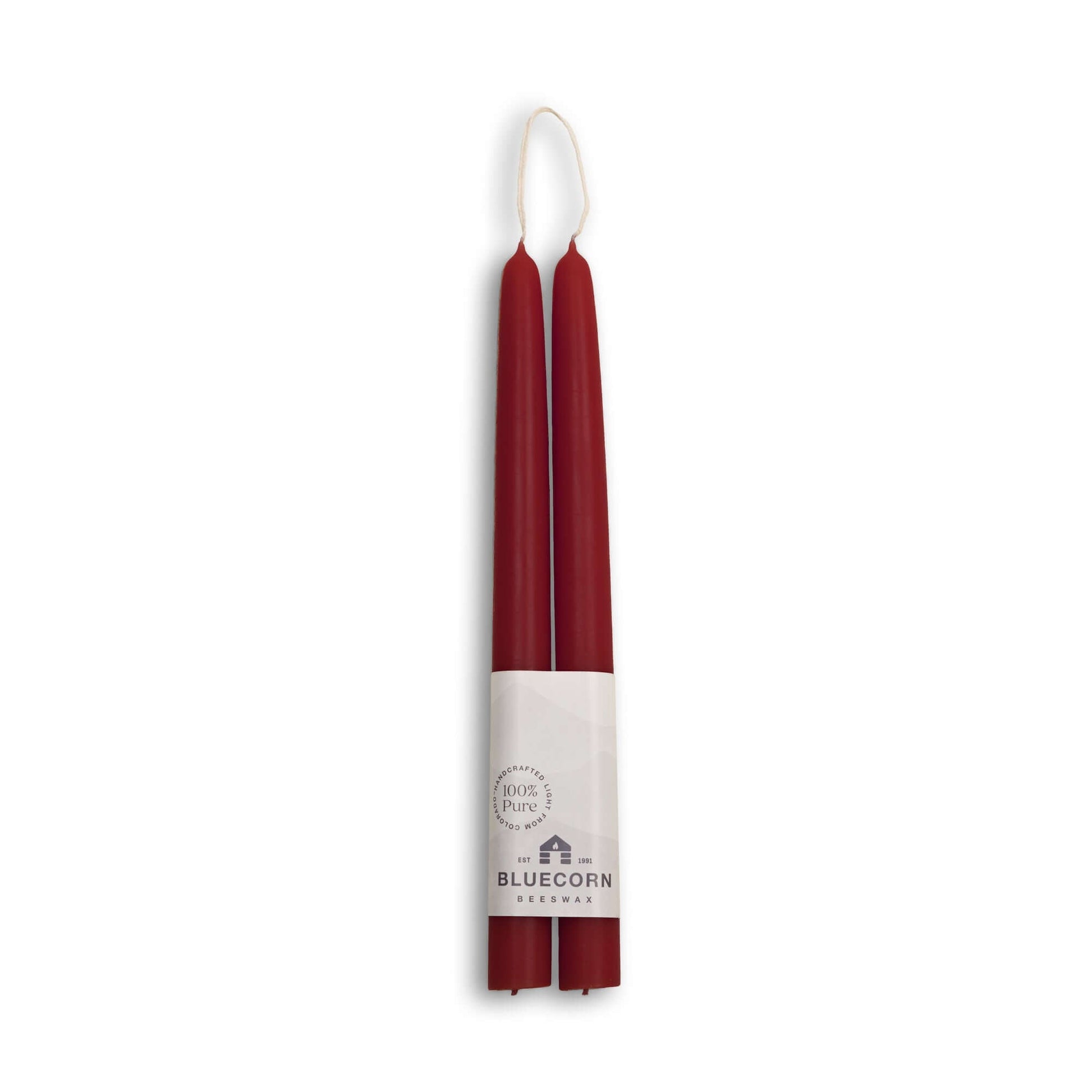 Two burgundy candles with a white label on a white background