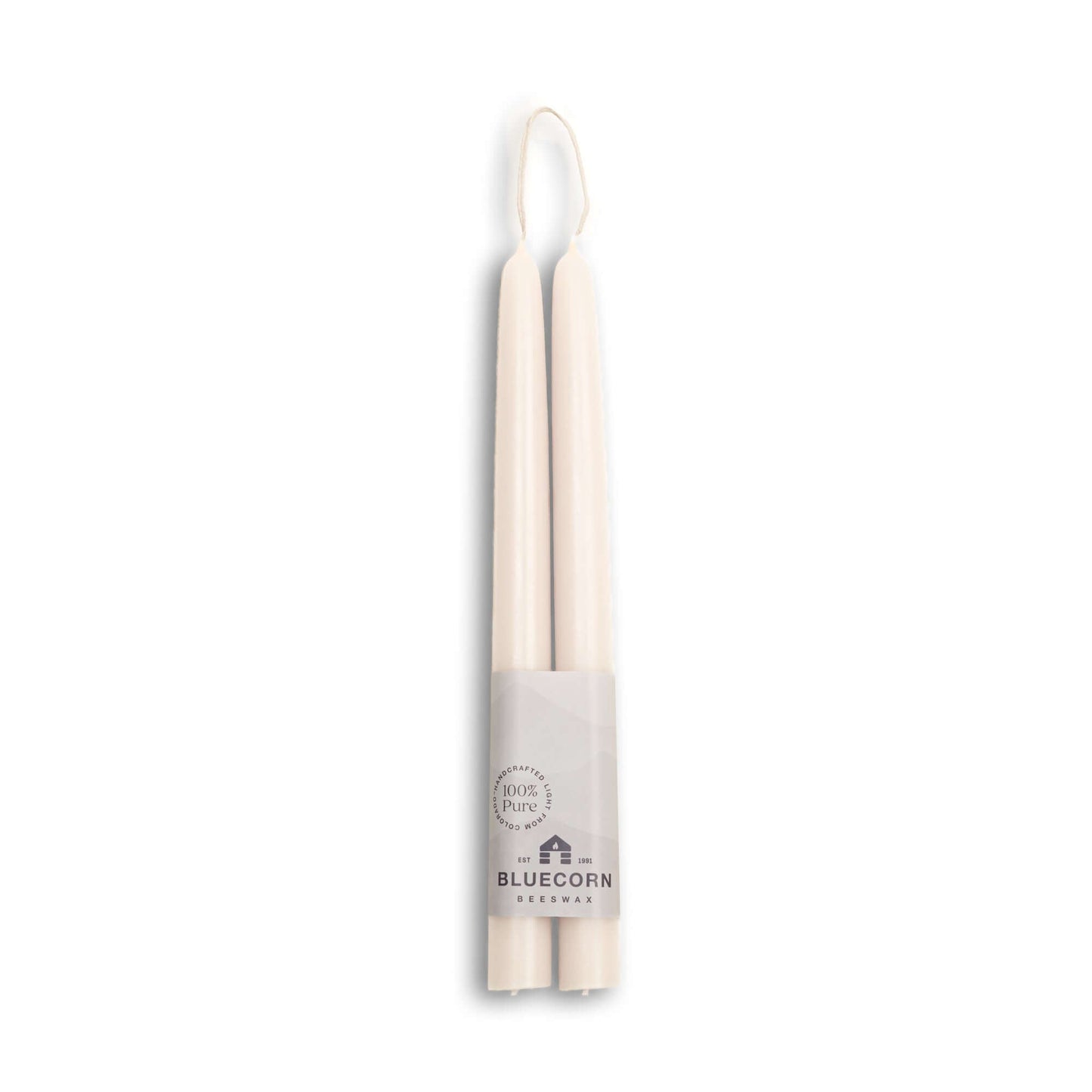 Two white beeswax candles in a cardboard holder with 'Bluecorn' branding on a white background