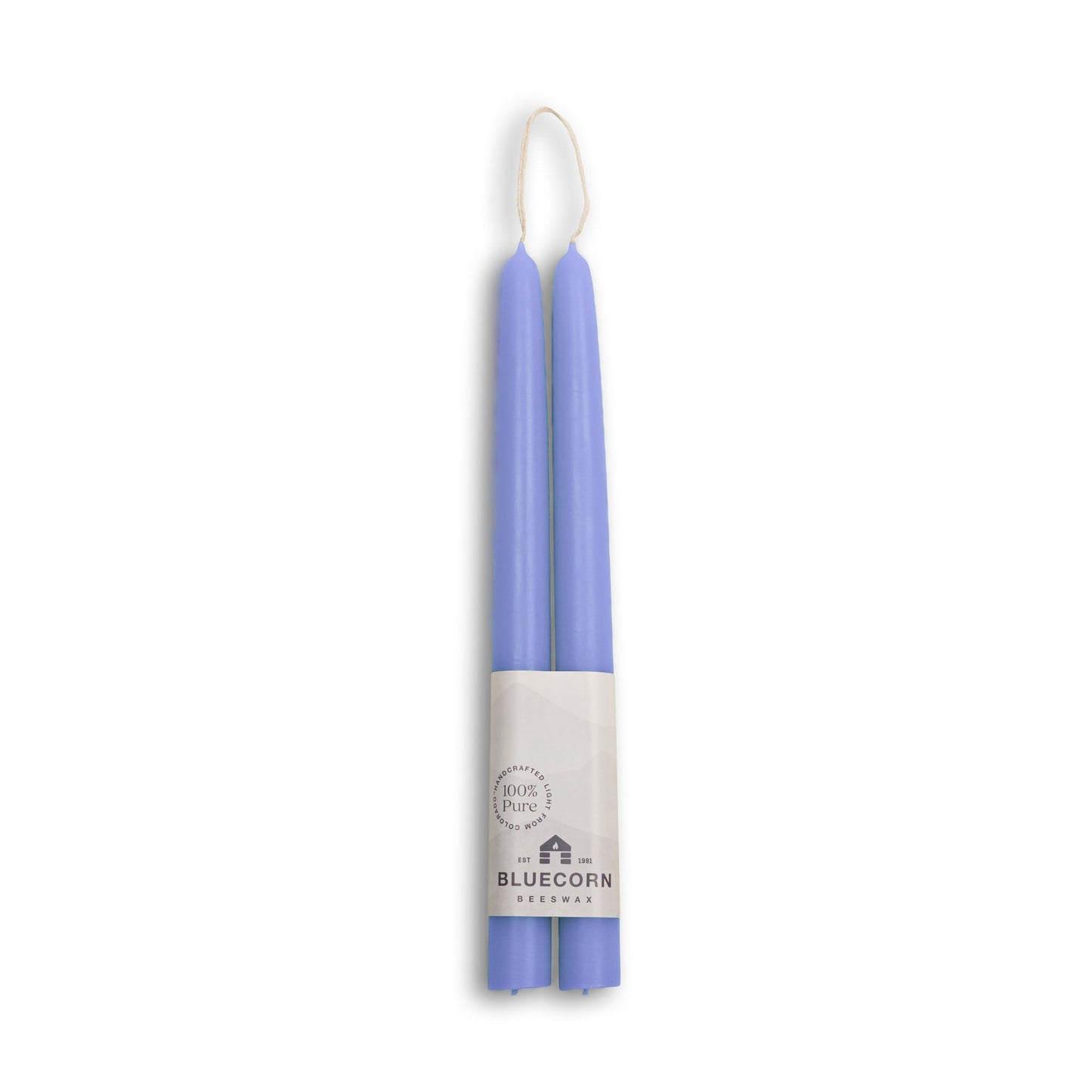 Two purple candles in packaging with a brand label on a white background