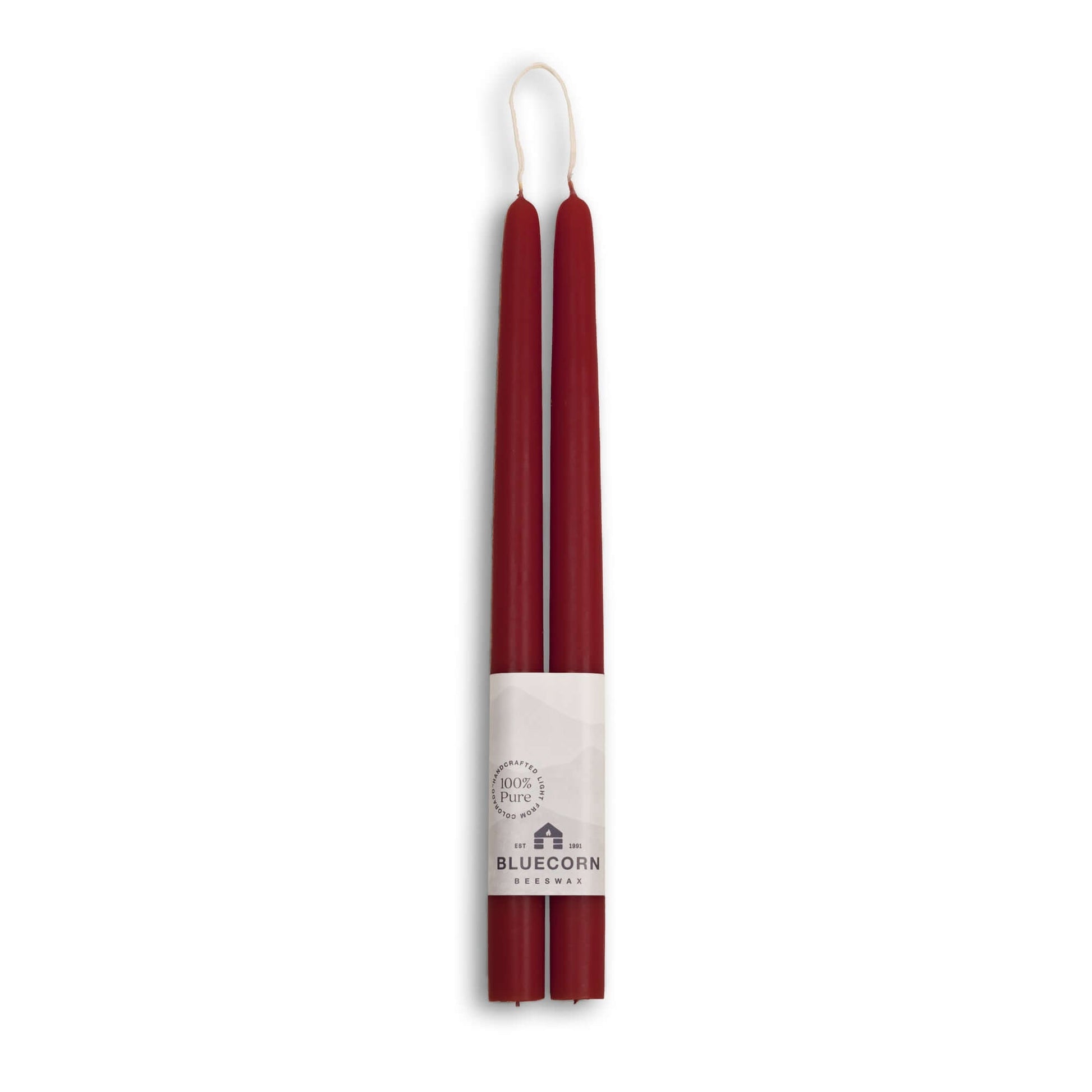 Two burgundy candles with a white label on a white background
