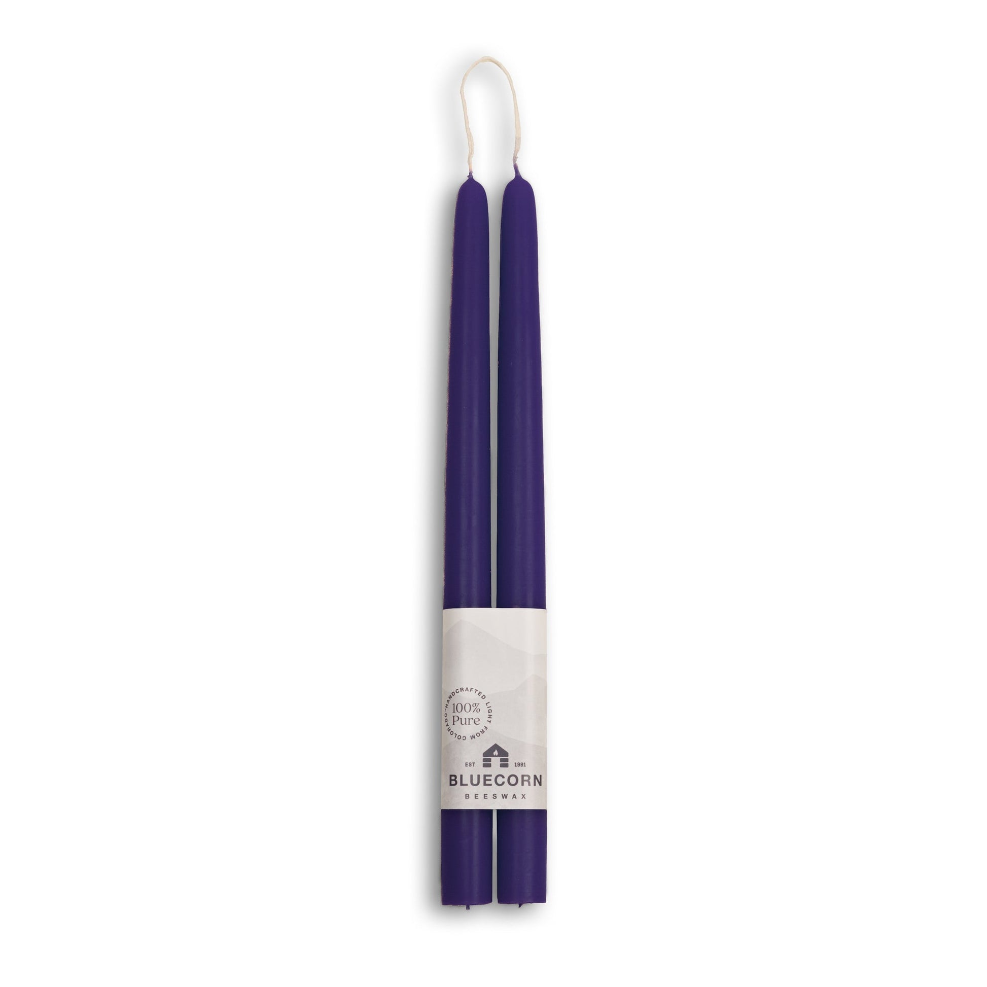 Two 12 inch eggplant candles with a white label on a white background