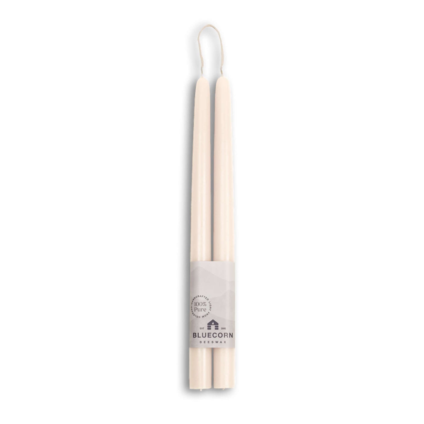 Two white candles with a label on a white background