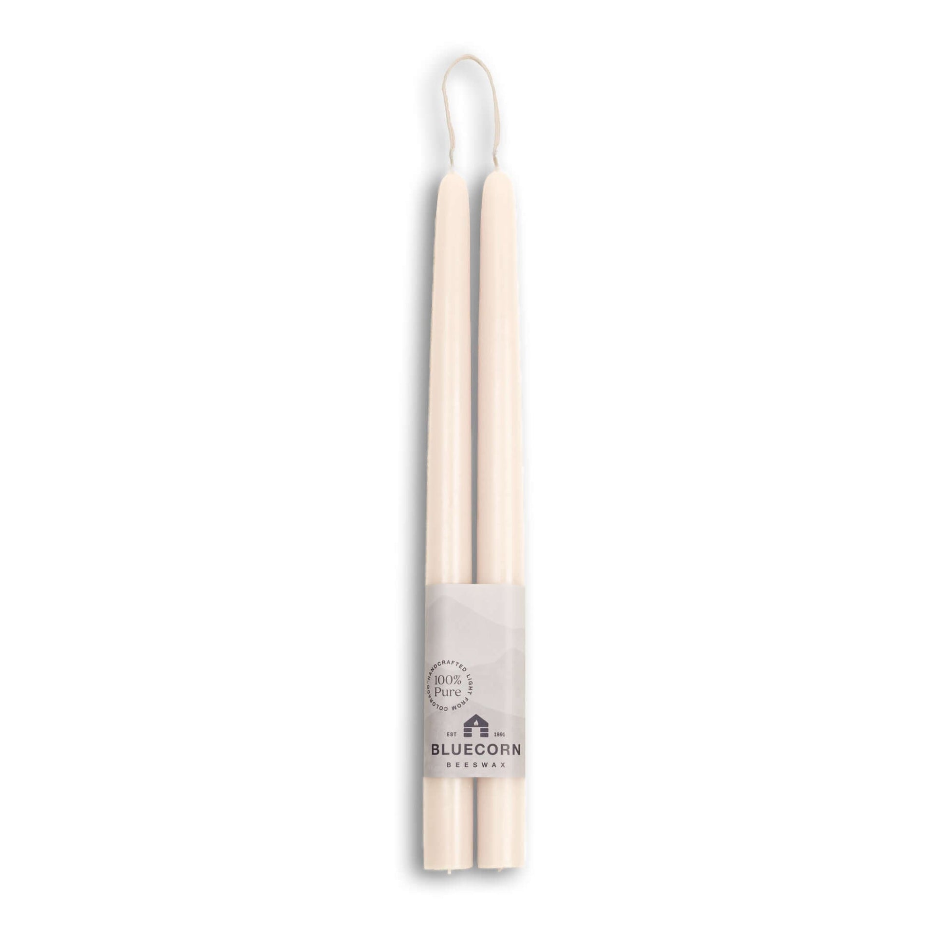 Two white candles with a label on a white background