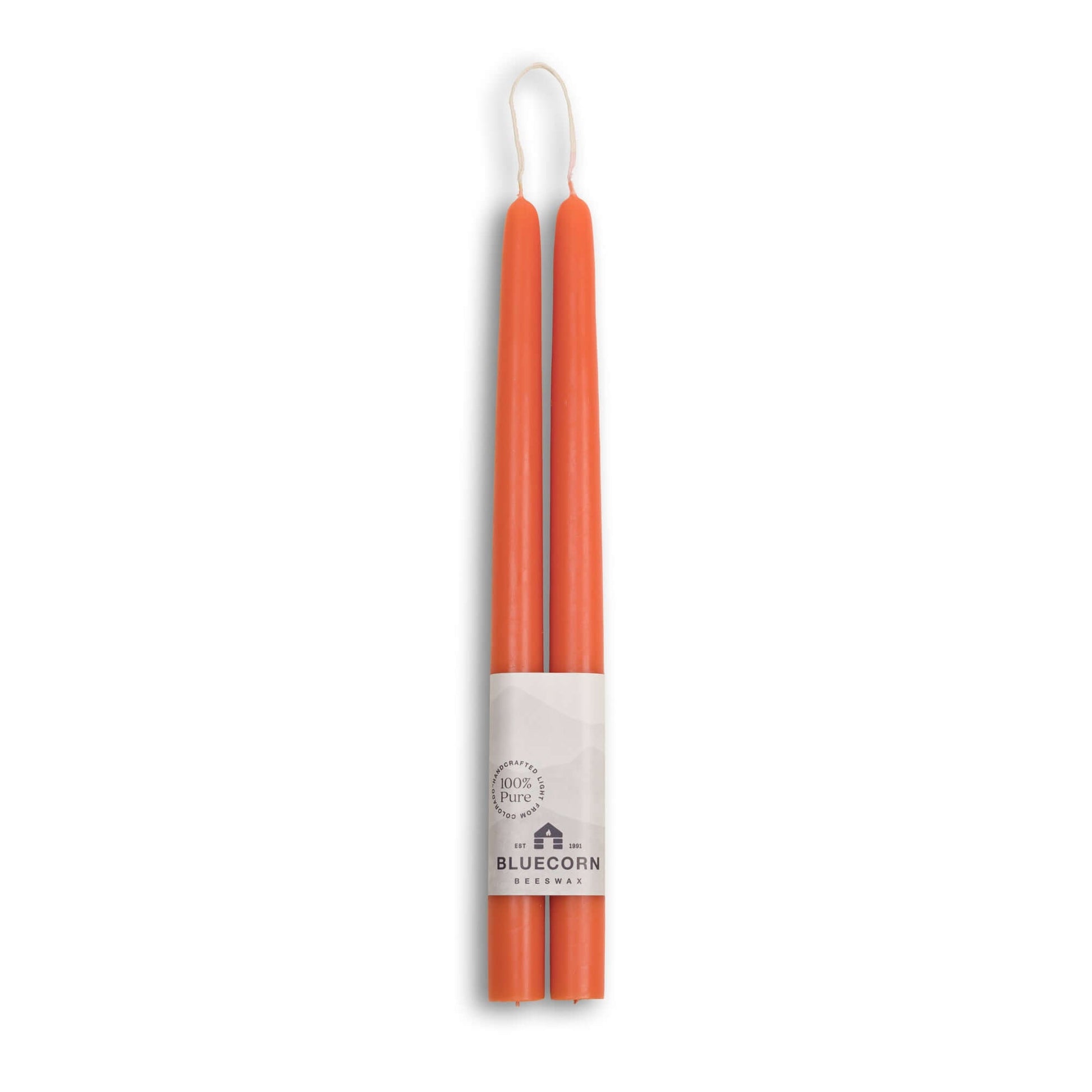 Two orange candles in a white holder with Bluecorn branding on a white background
