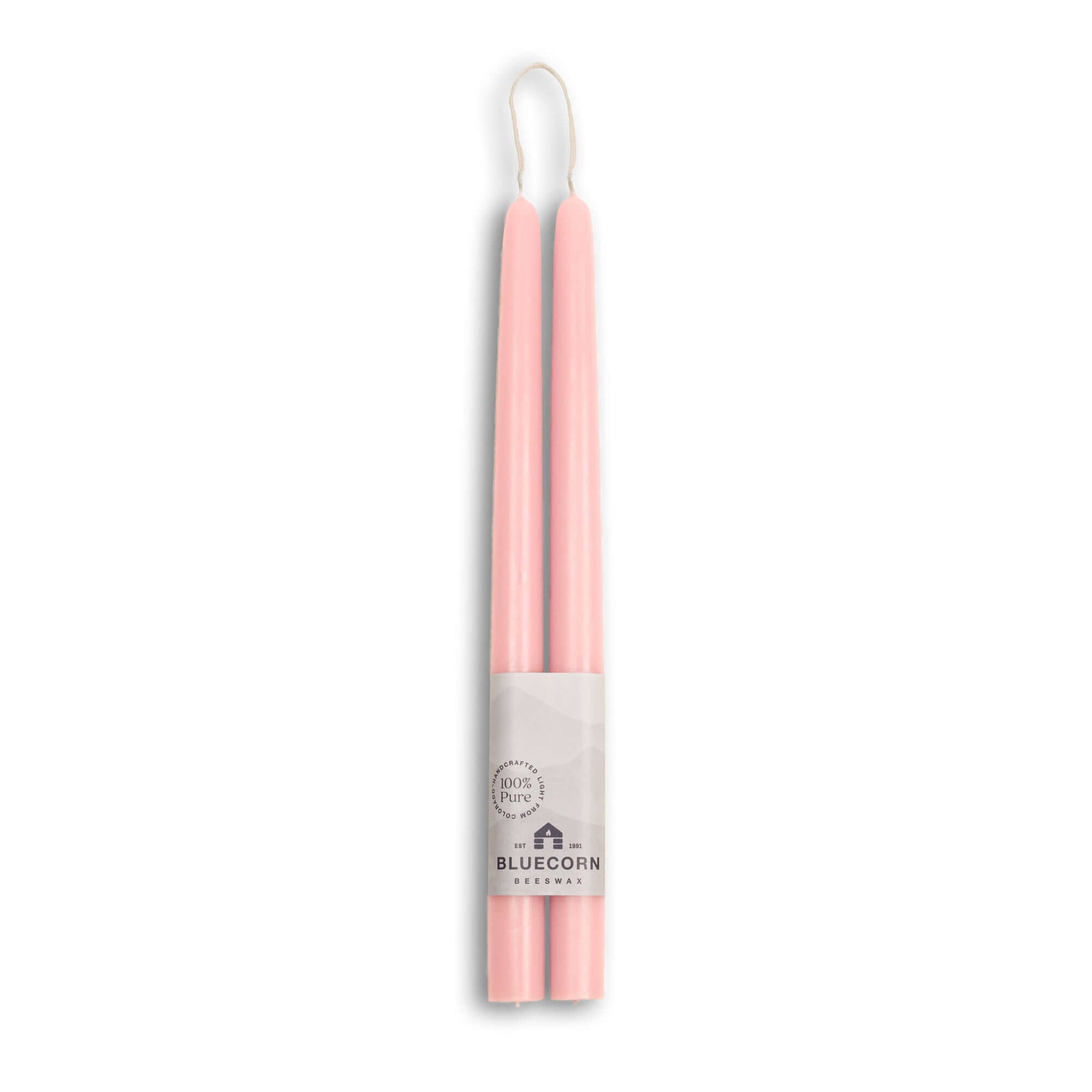 Two pink candles in a white holder with 'Bluecorn' branding on a white background