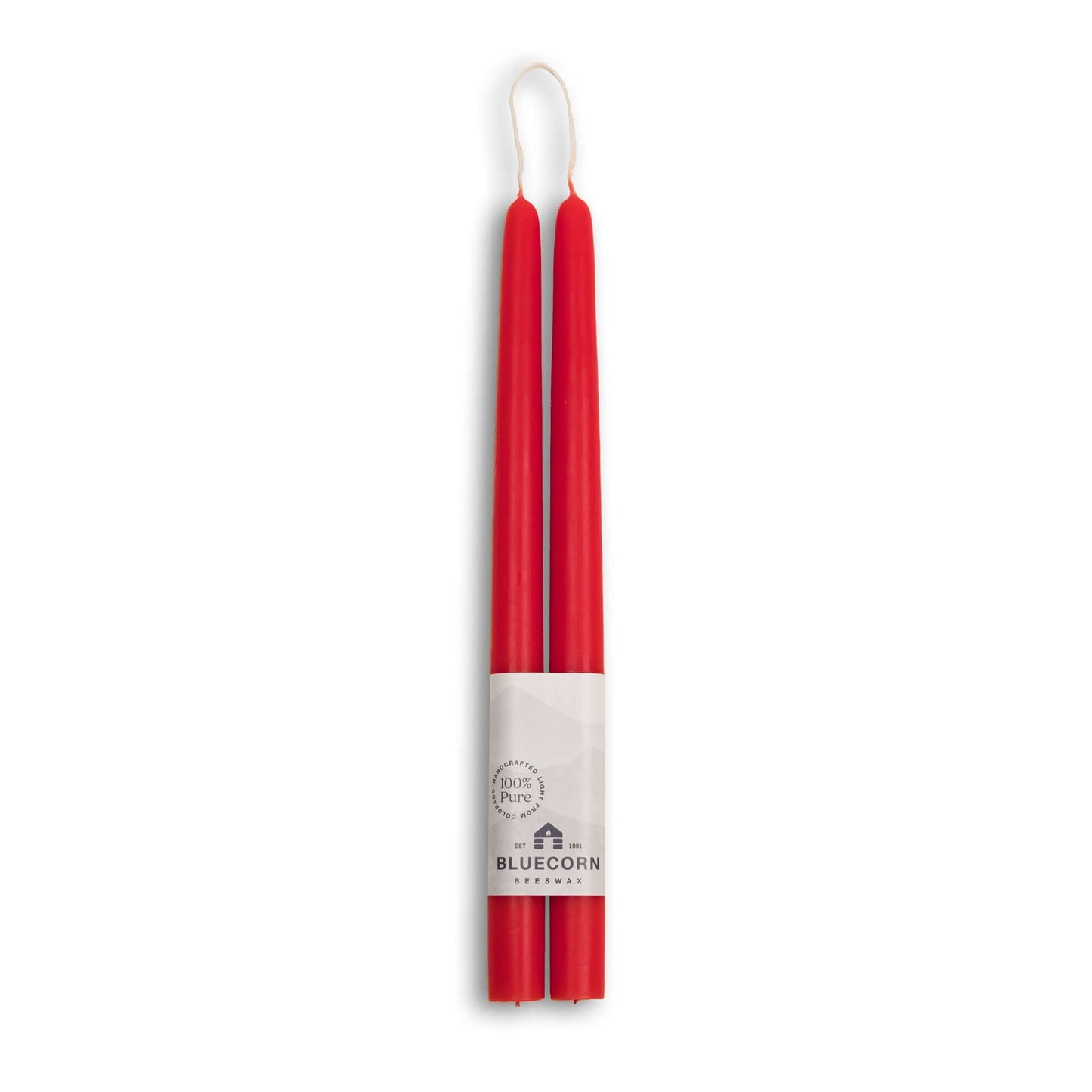 Two red candles with a white label on a white background