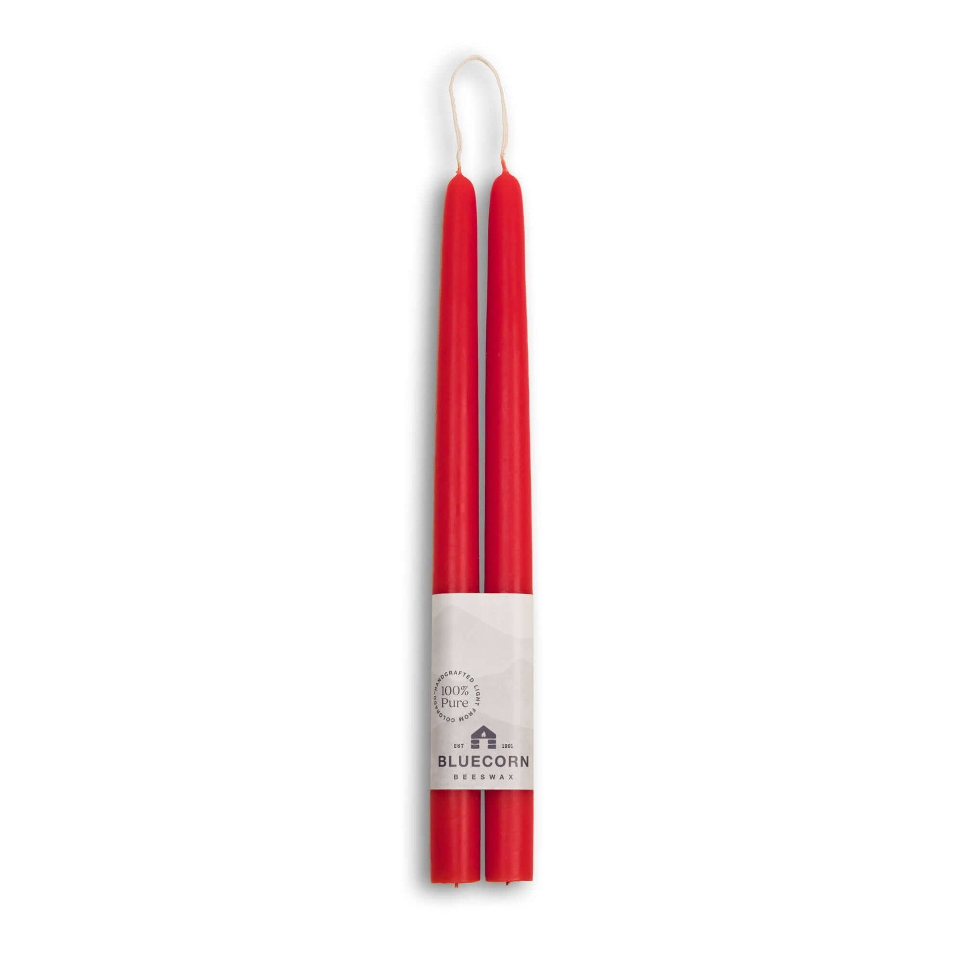Two red candles with a white label on a white background