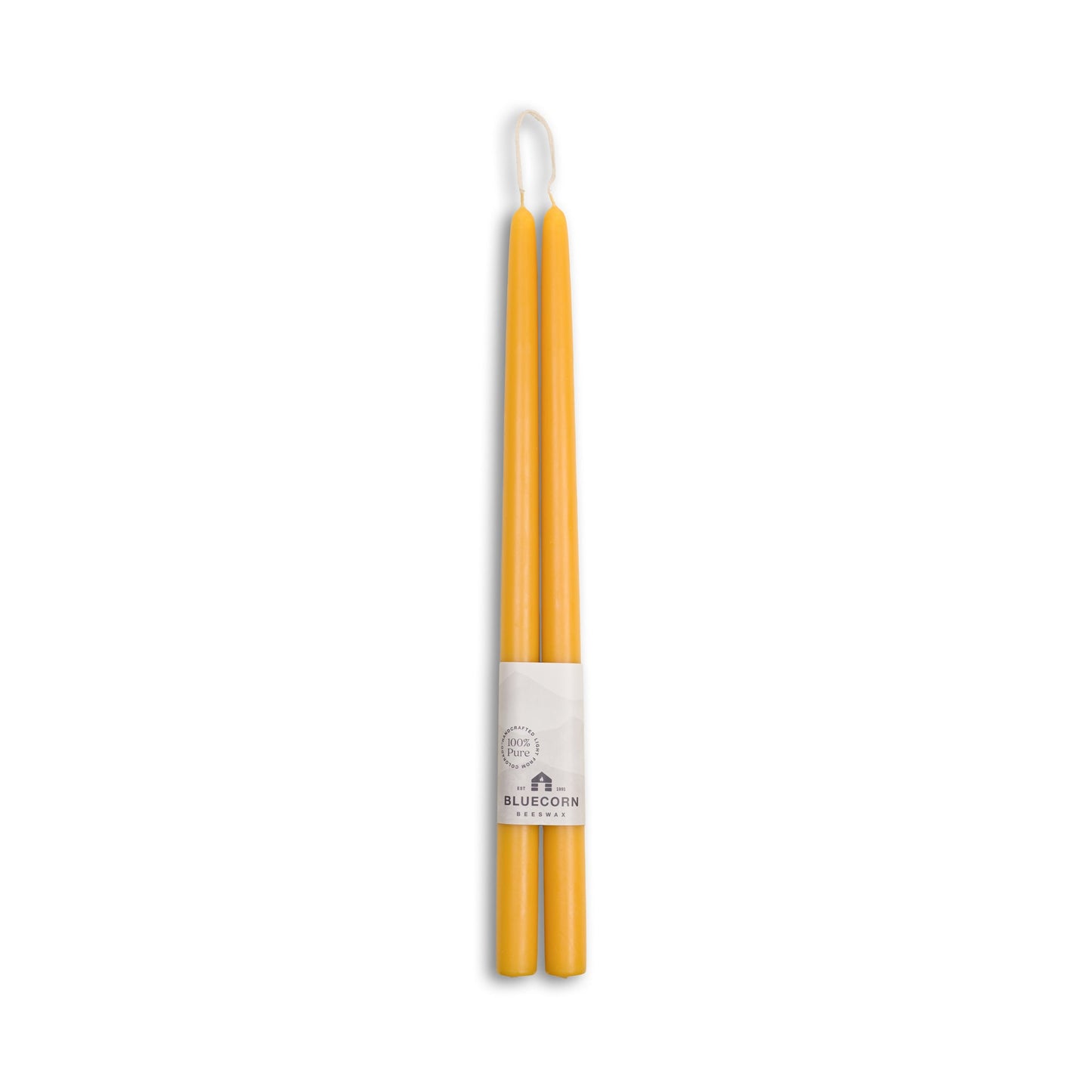 Two yellow candles with a white label on a white background