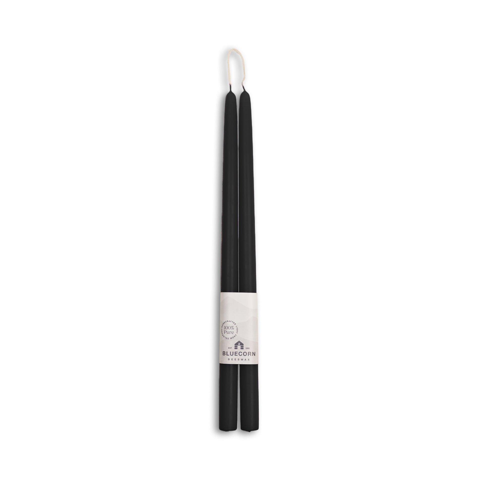 Black candle with a white label on a white background
