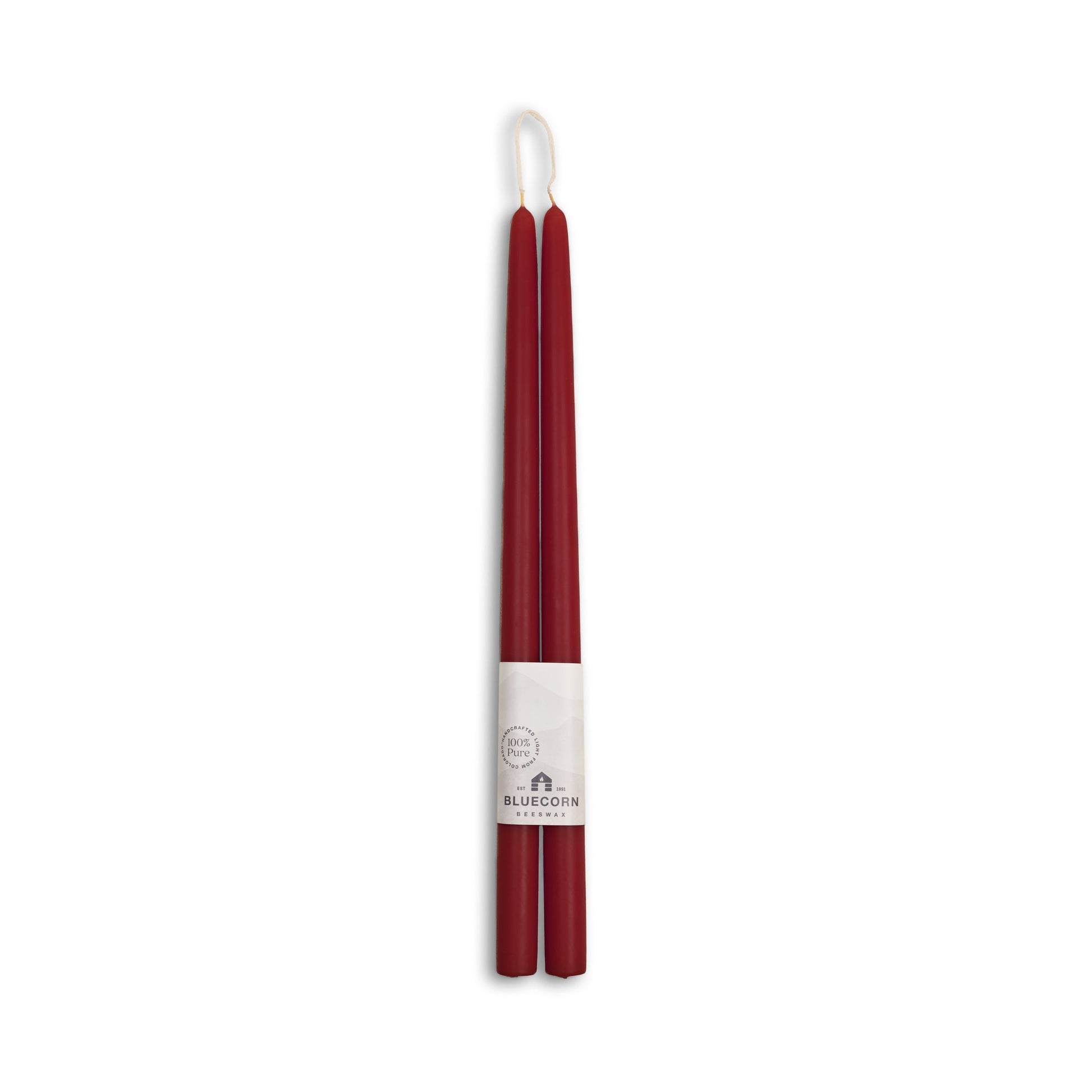 Two burgundy candles with a white label on a white background