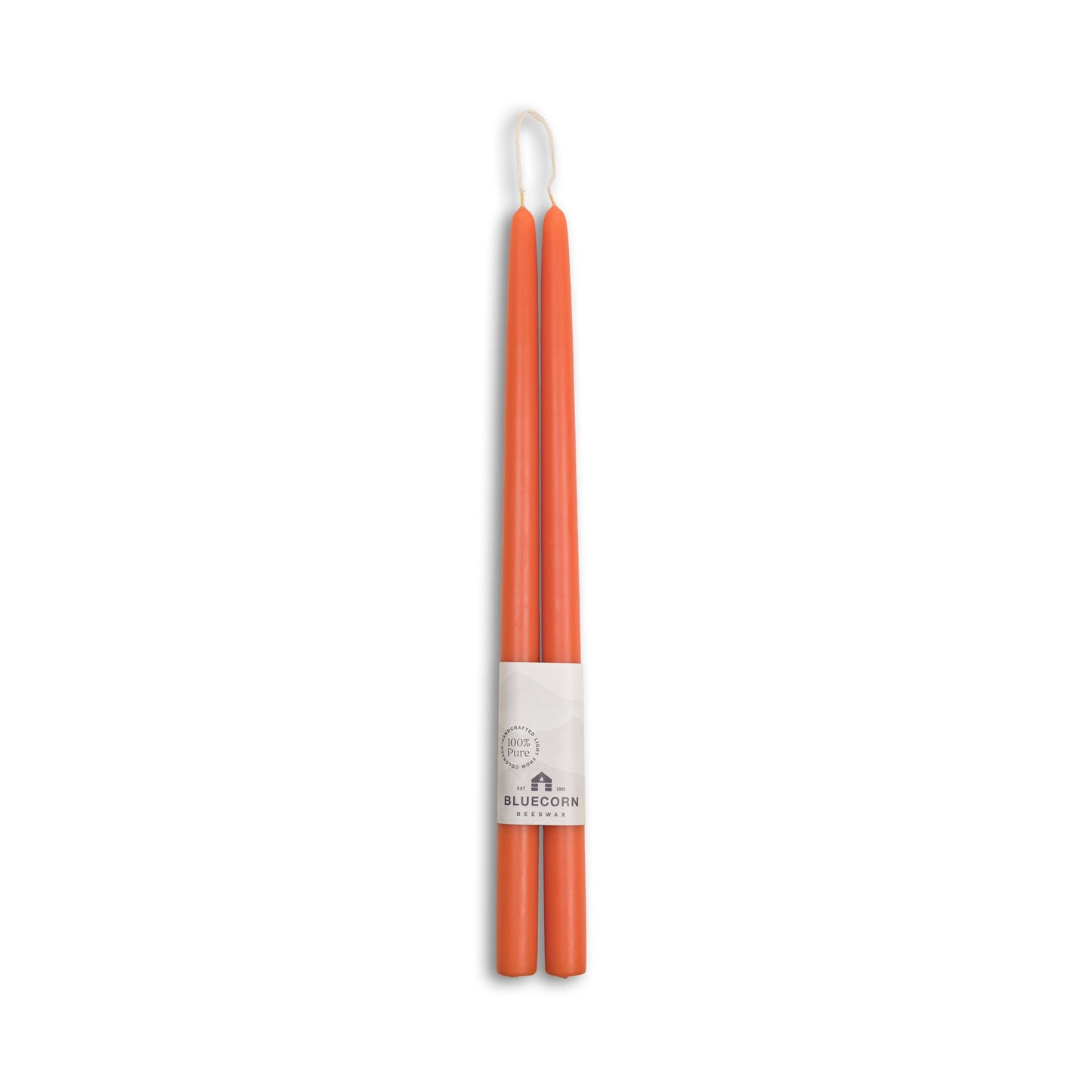 Pair of orange candles with a white label on a white background