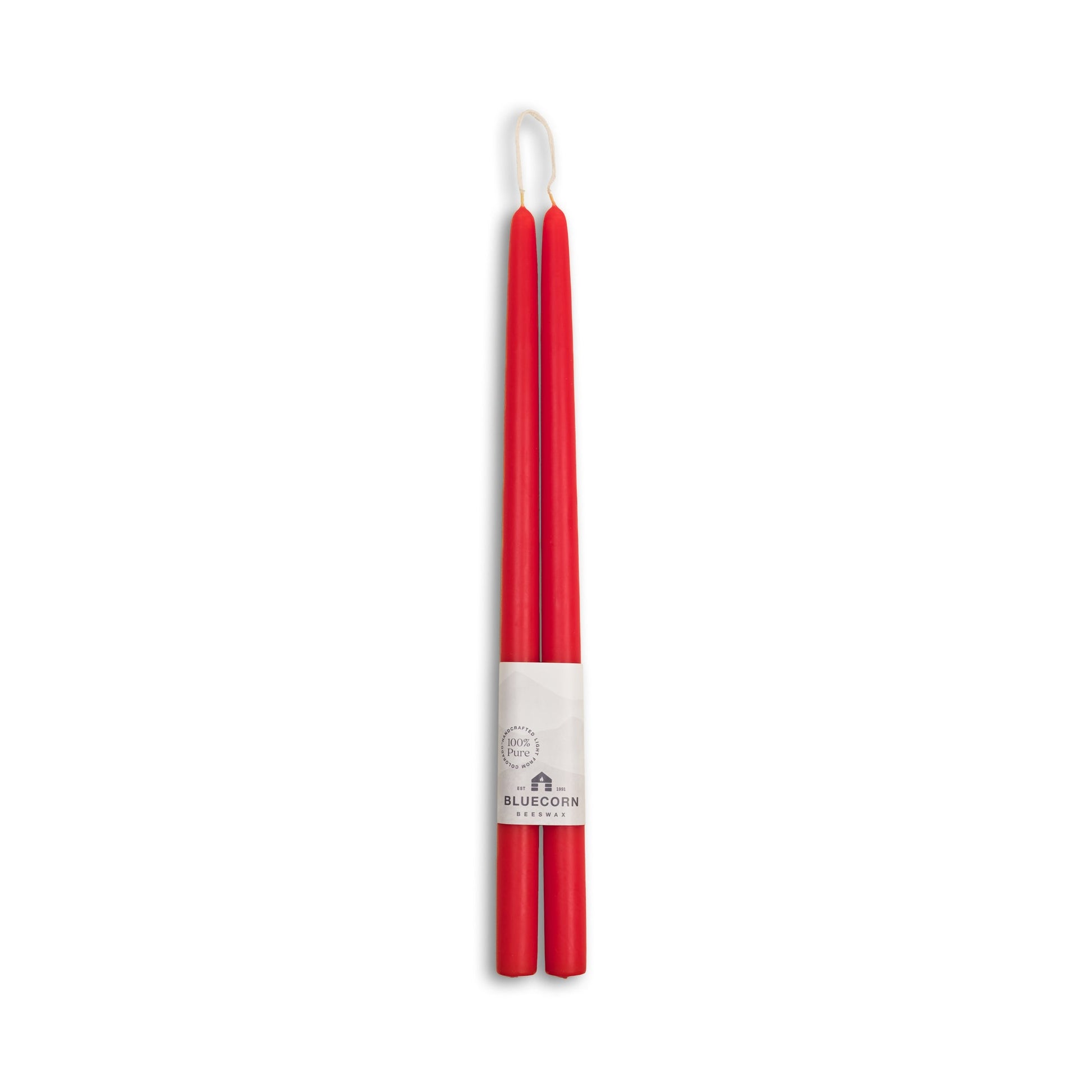 Two red candles with a white label on a white background