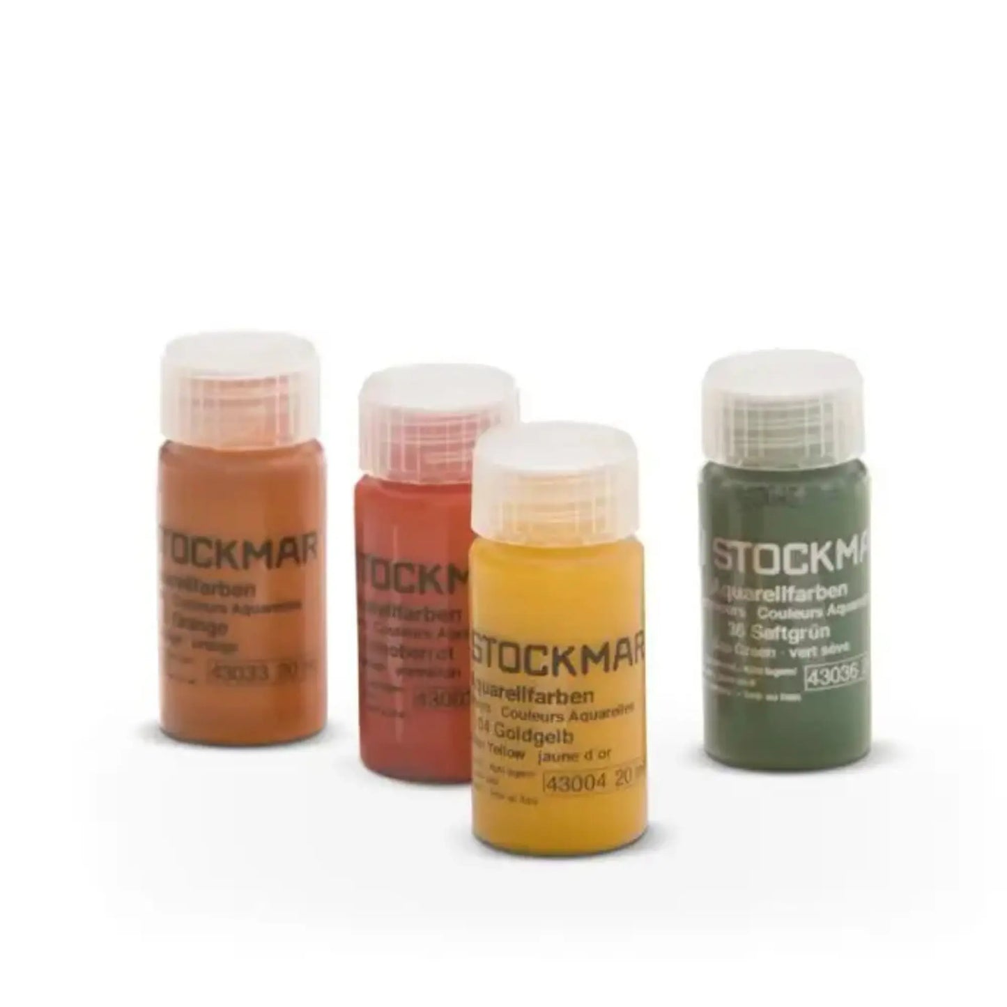 Four bottles of Stockmar watercolor paint in different colors on a white background