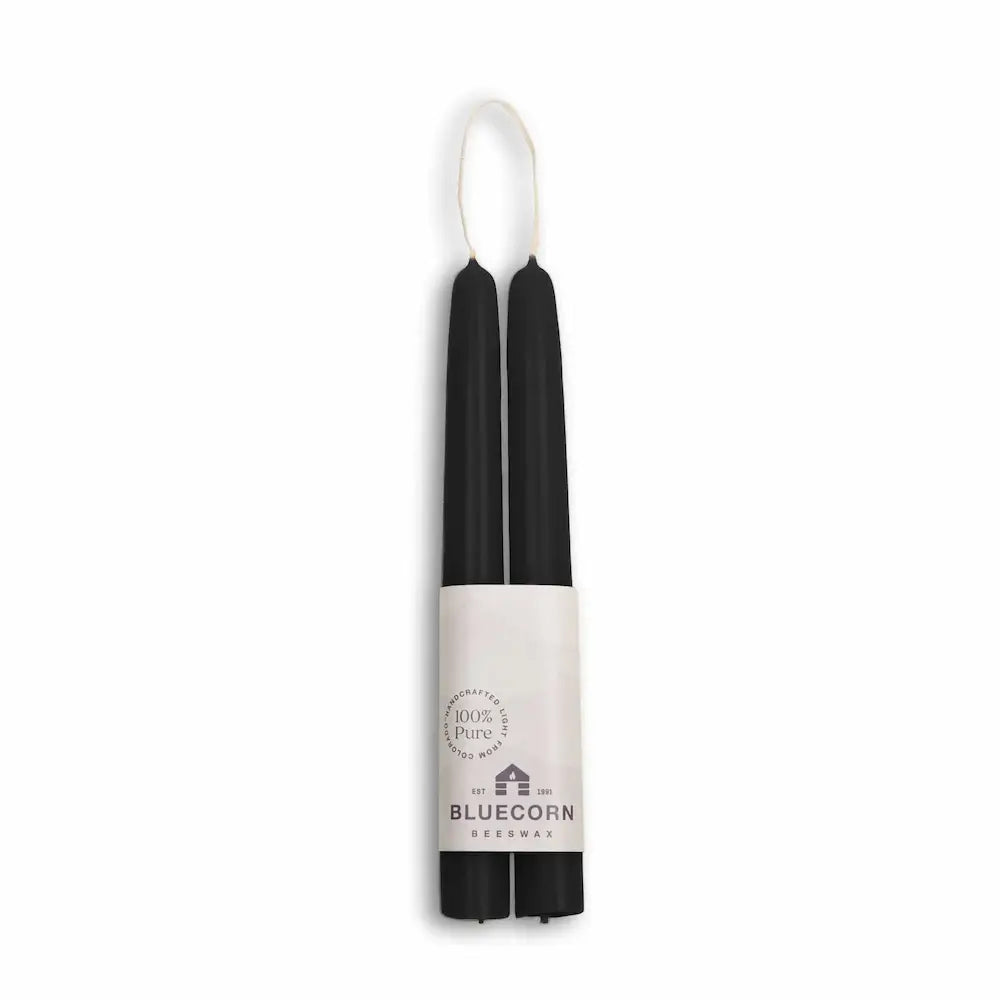 Black candles with a white container labeled 'Bluecorn' on a white background