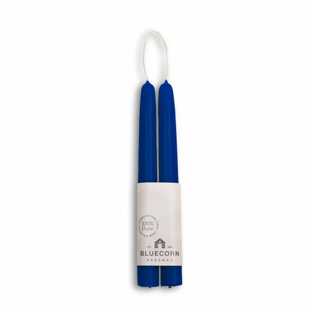 Two blue candles in a white holder with 'Bluecorn' branding on a white background