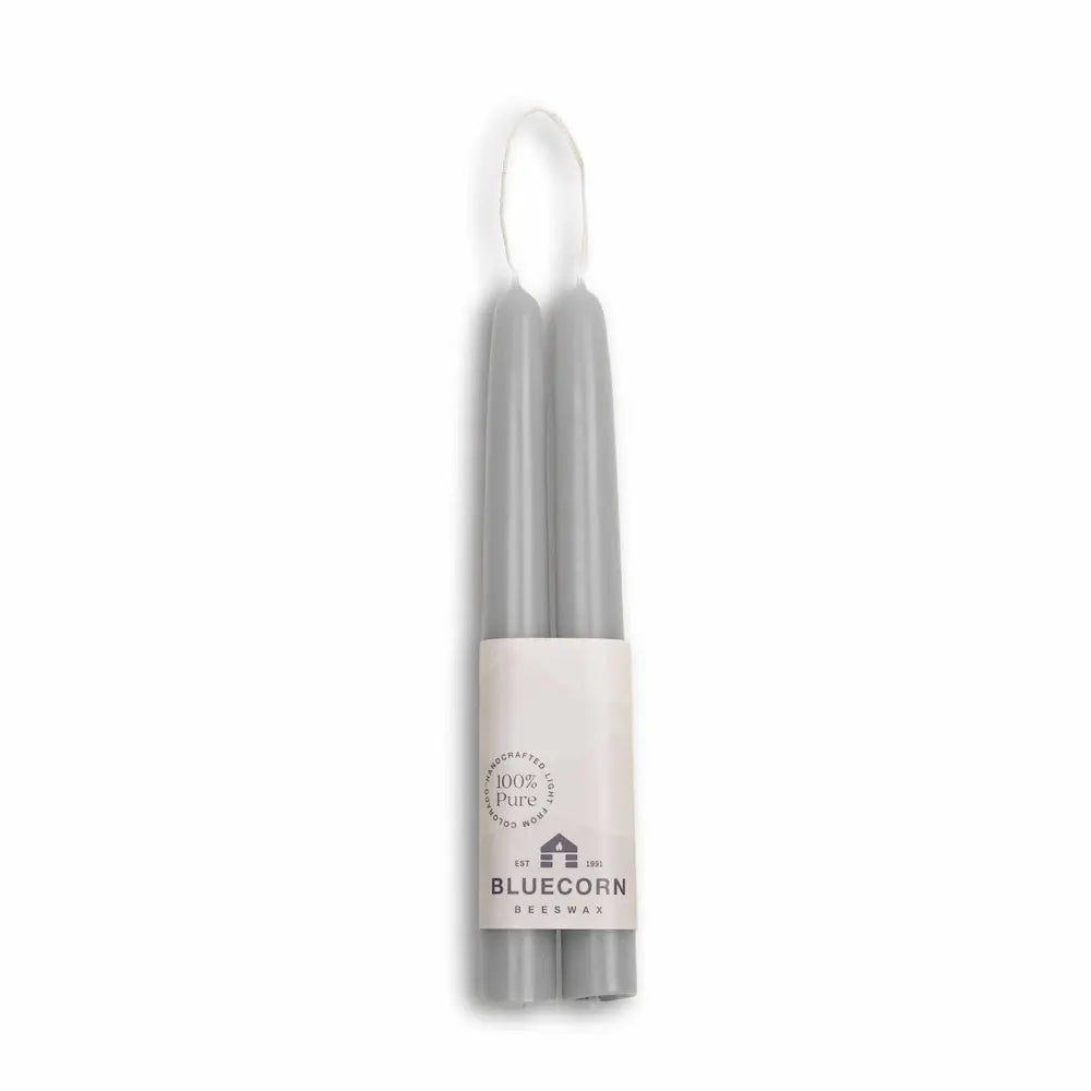 Two gray candles in a holder with a Bluecorn label on a white background