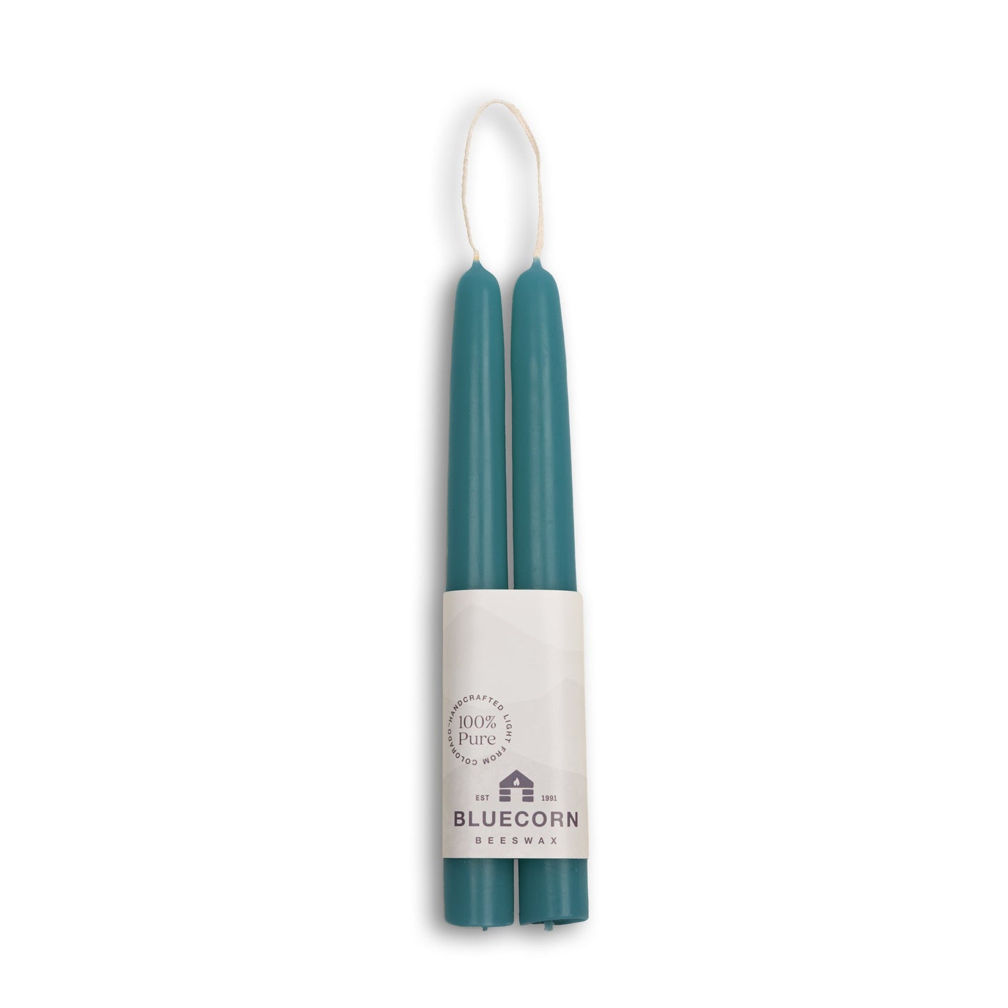 Two teal candles in a white cylindrical holder with 'Bluecorn' branding on a white background.