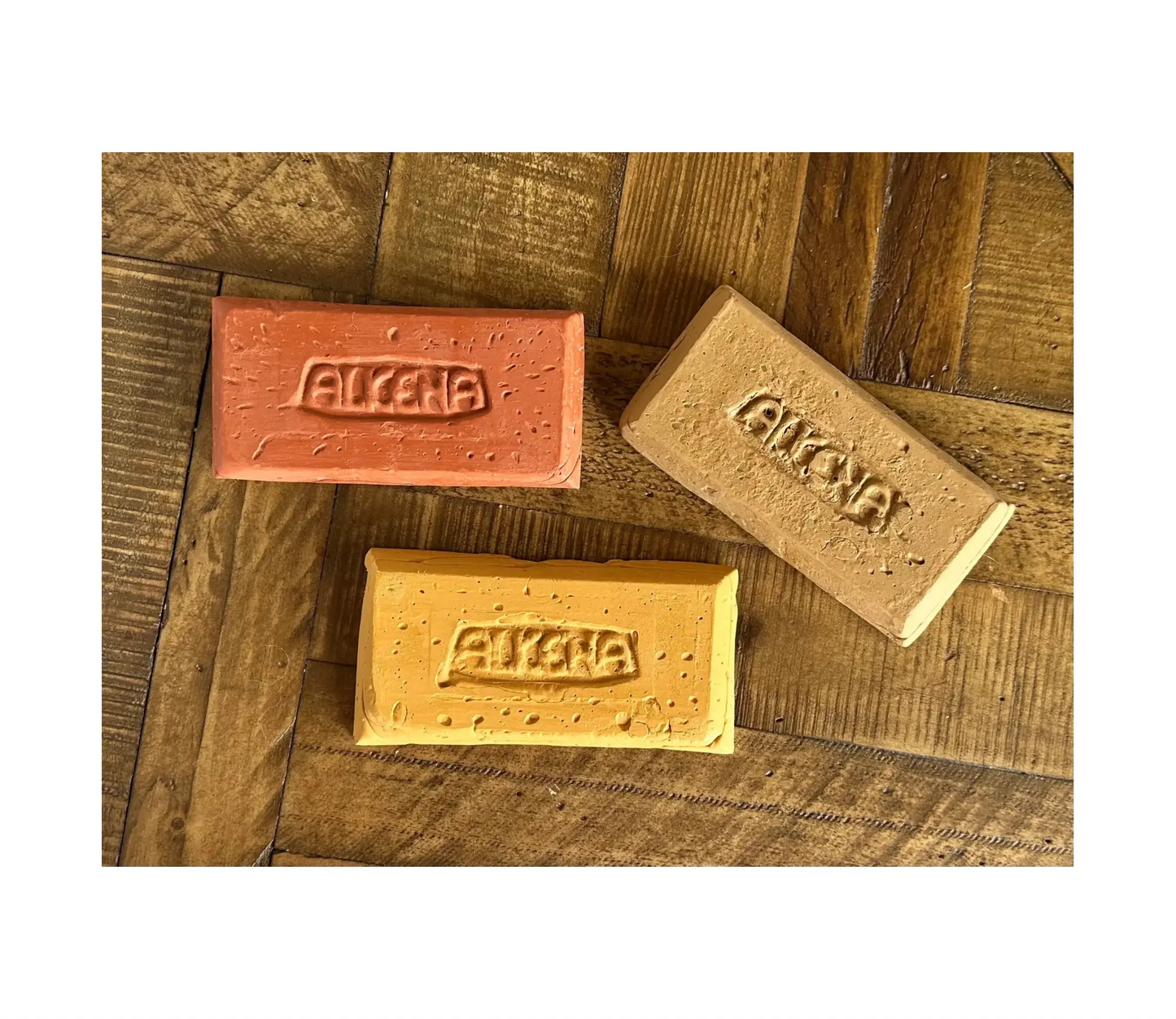 Three Alkena beeswax modeling clay bars with on a table top
