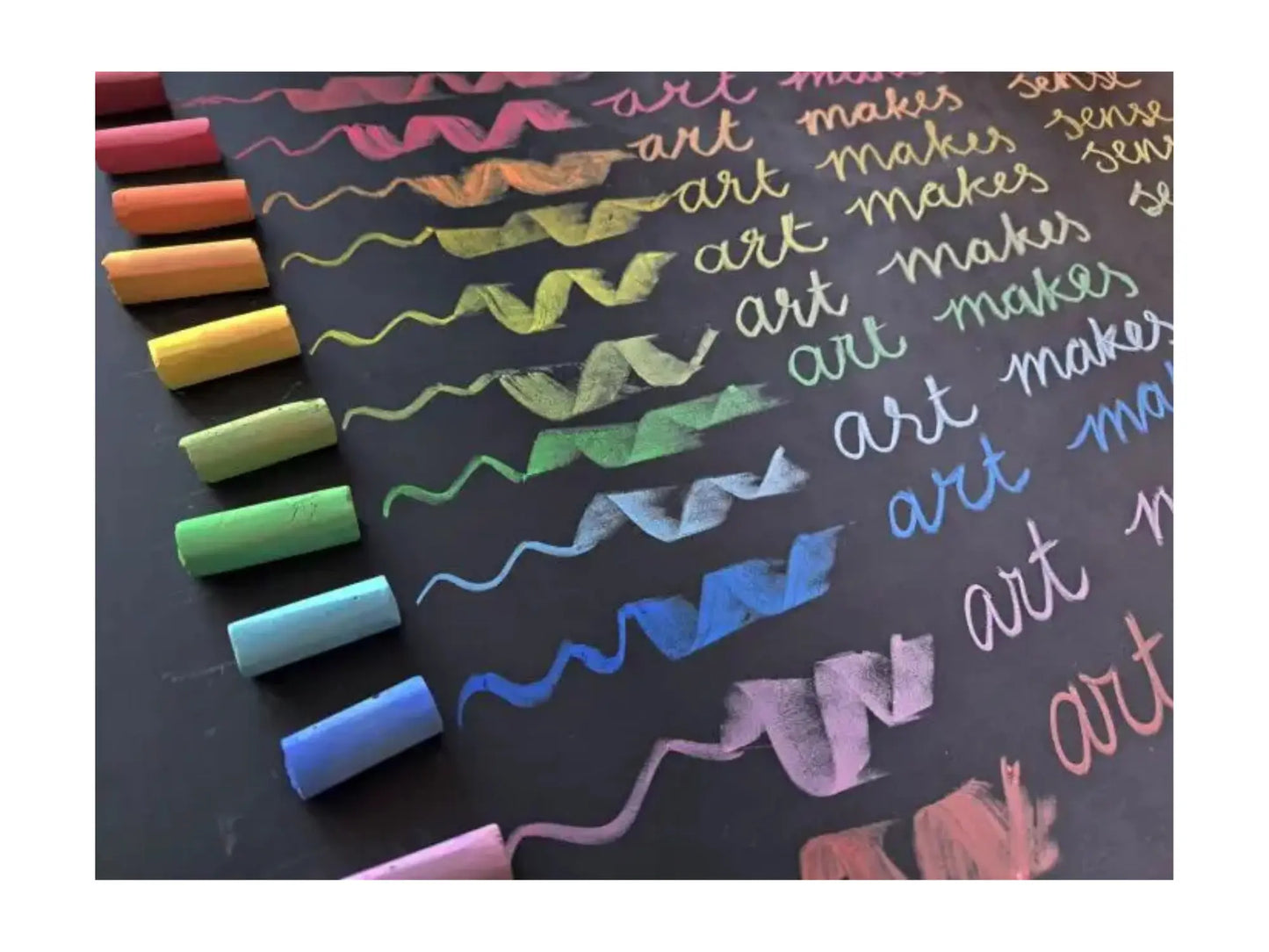 Colorful chalks on a blackboard with written text