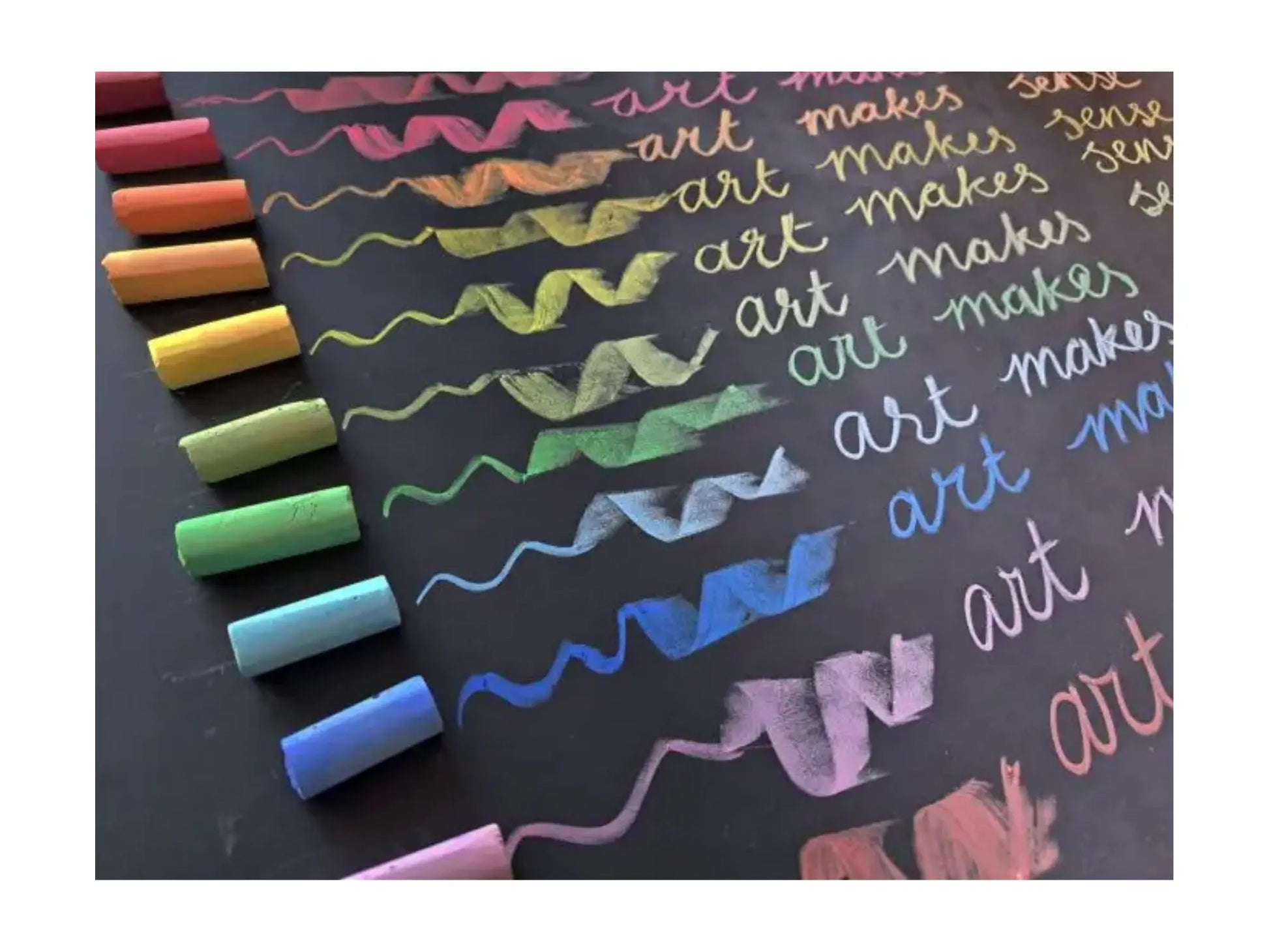 Colorful chalks on a blackboard with written text