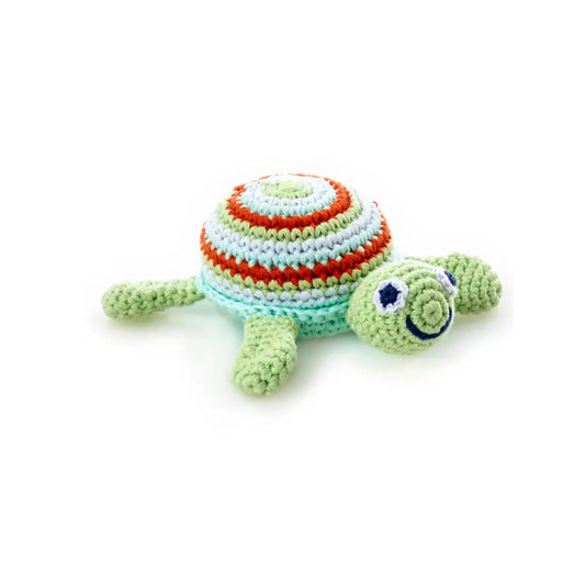 Close-up of handmade knitted sea turtle baby rattle in soft cotton yarn