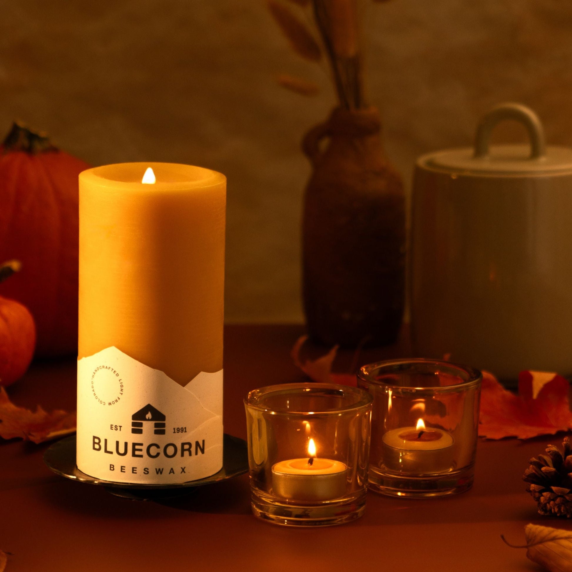 Candle with Bluecorn label on a table with decorative items